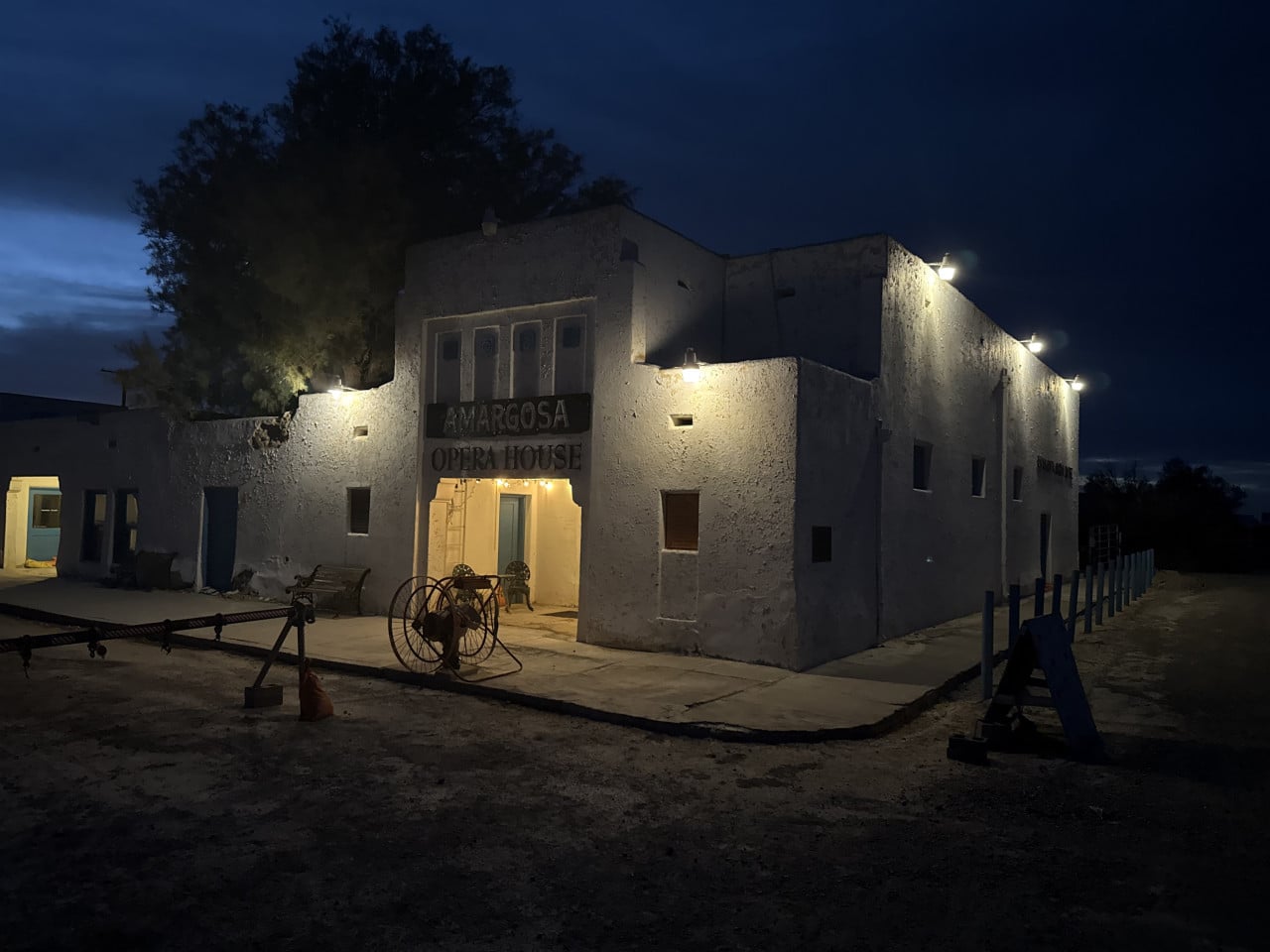 Noční budova Amargosa Opera House v pouštní krajině, osvětlený vchod a nápis AMARGOSA OPERA HOUSE