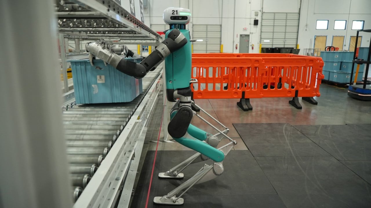 Humanoidní robot Digit u dopravníku v továrně.