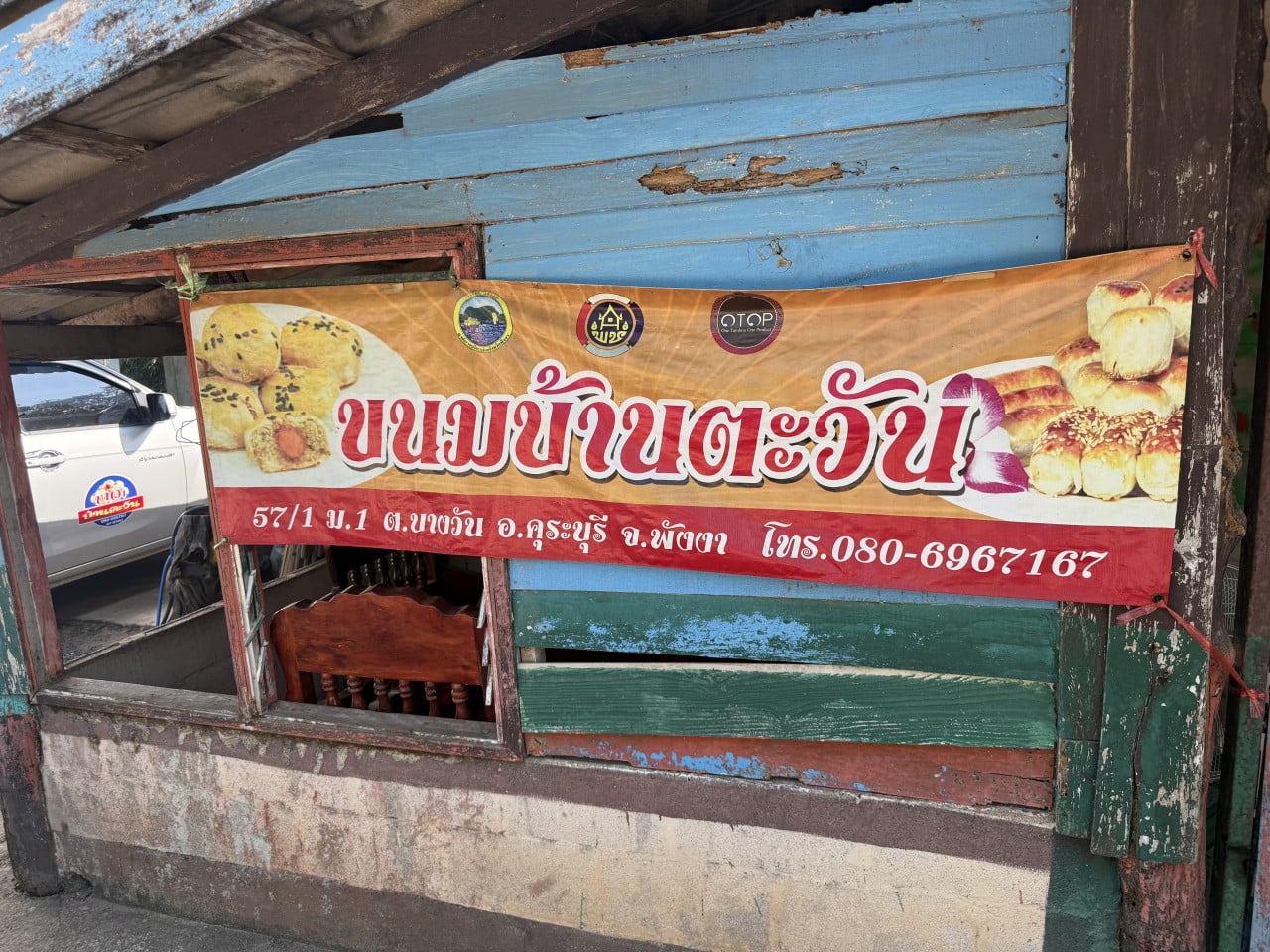 Reklamní banner s thajským nápisem na koláčky, fotky pečiva, telefon 080-6967167.