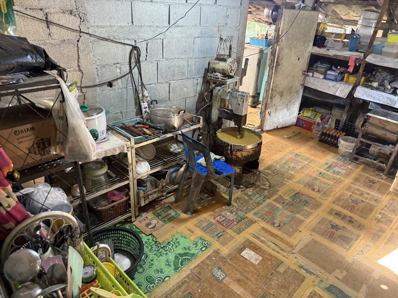 Rustikální thajská kuchyň s míchacím strojem, hrncem těsta a krabicí SIAM.