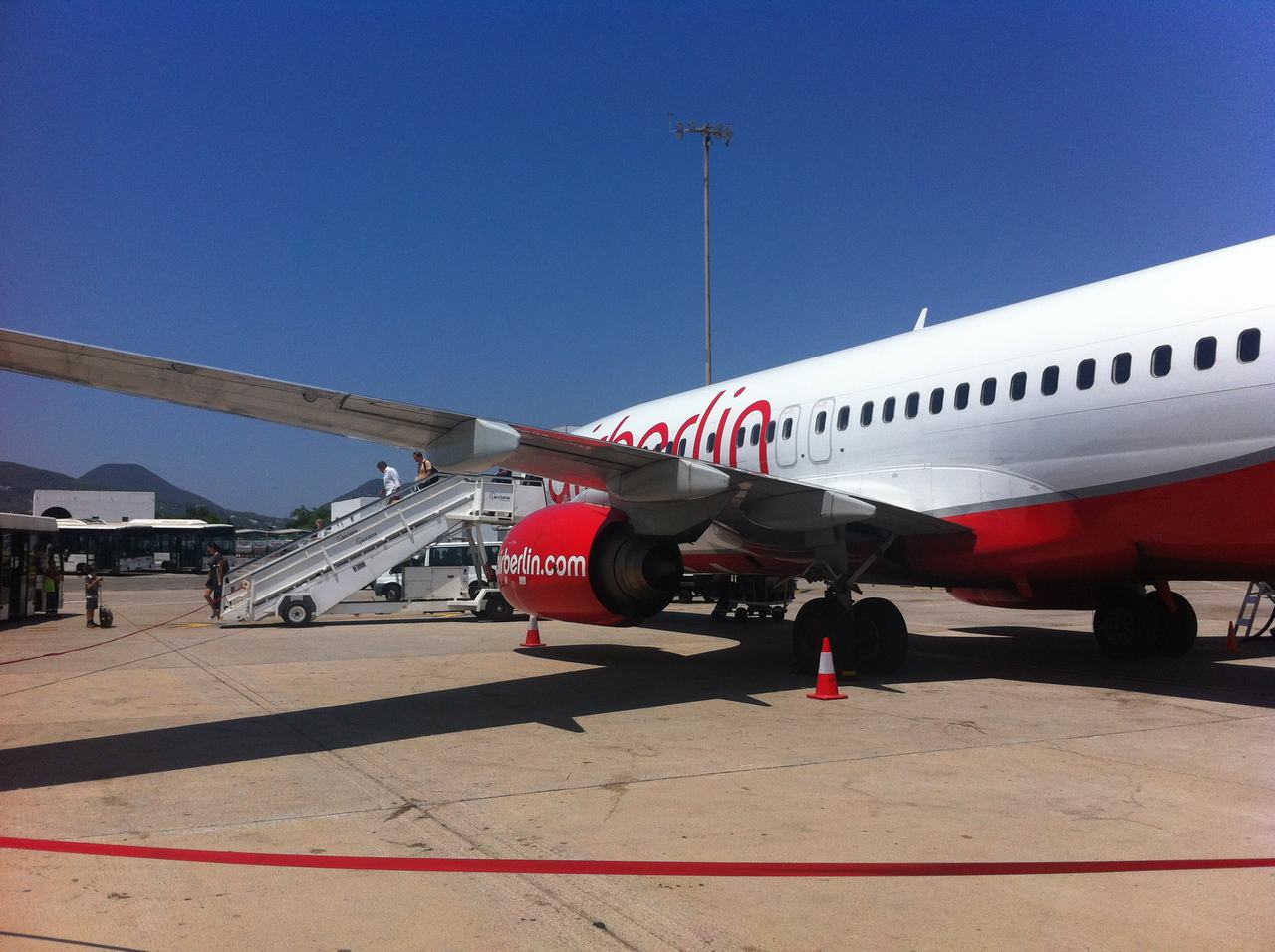 Letadlo airberlin na letištní ploše, cestující nastupují po schodech, nápis airberlin.com