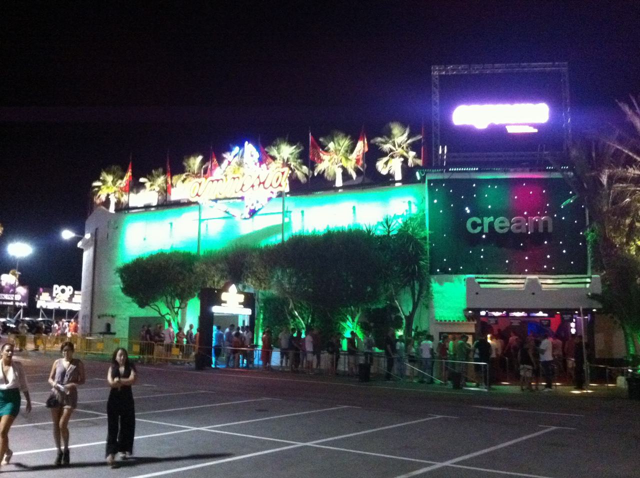 Noční klub Amnesia s nápisem cream, palmy a lidé ve frontě před vstupem