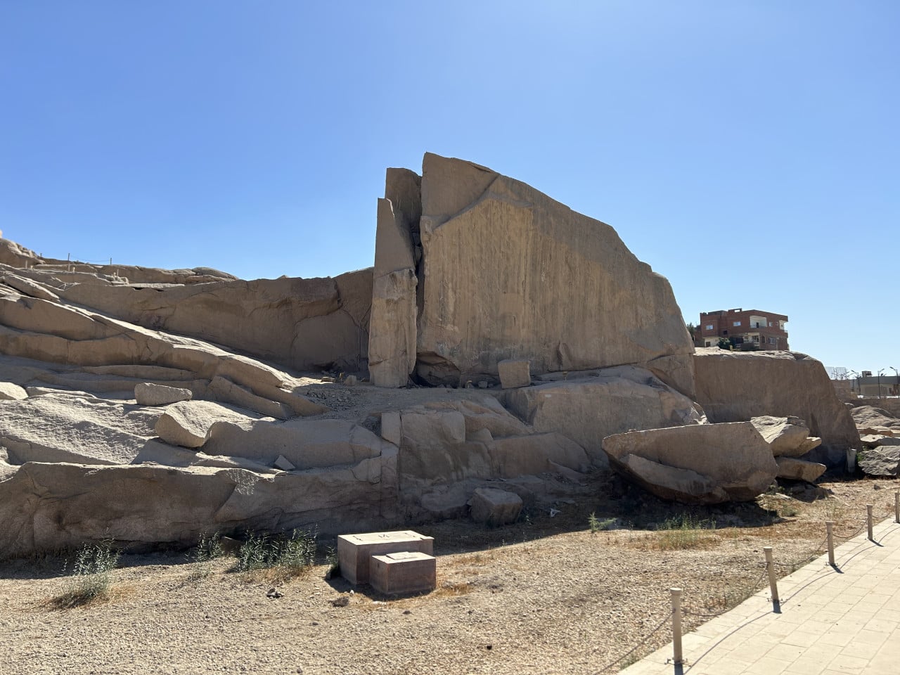 Nedokončený obelisk v Asuánu, obrovský opracovaný žulový blok pod modrou oblohou