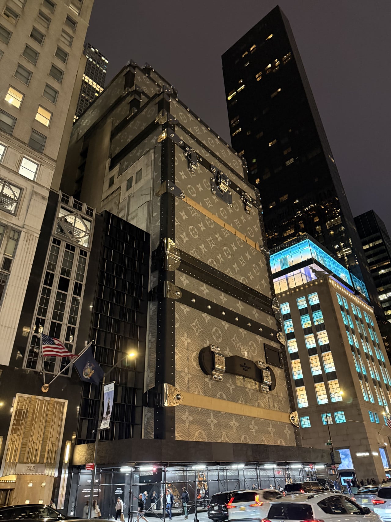 Obří kufr Louis Vuitton před mrakodrapy na Fifth Avenue v noci