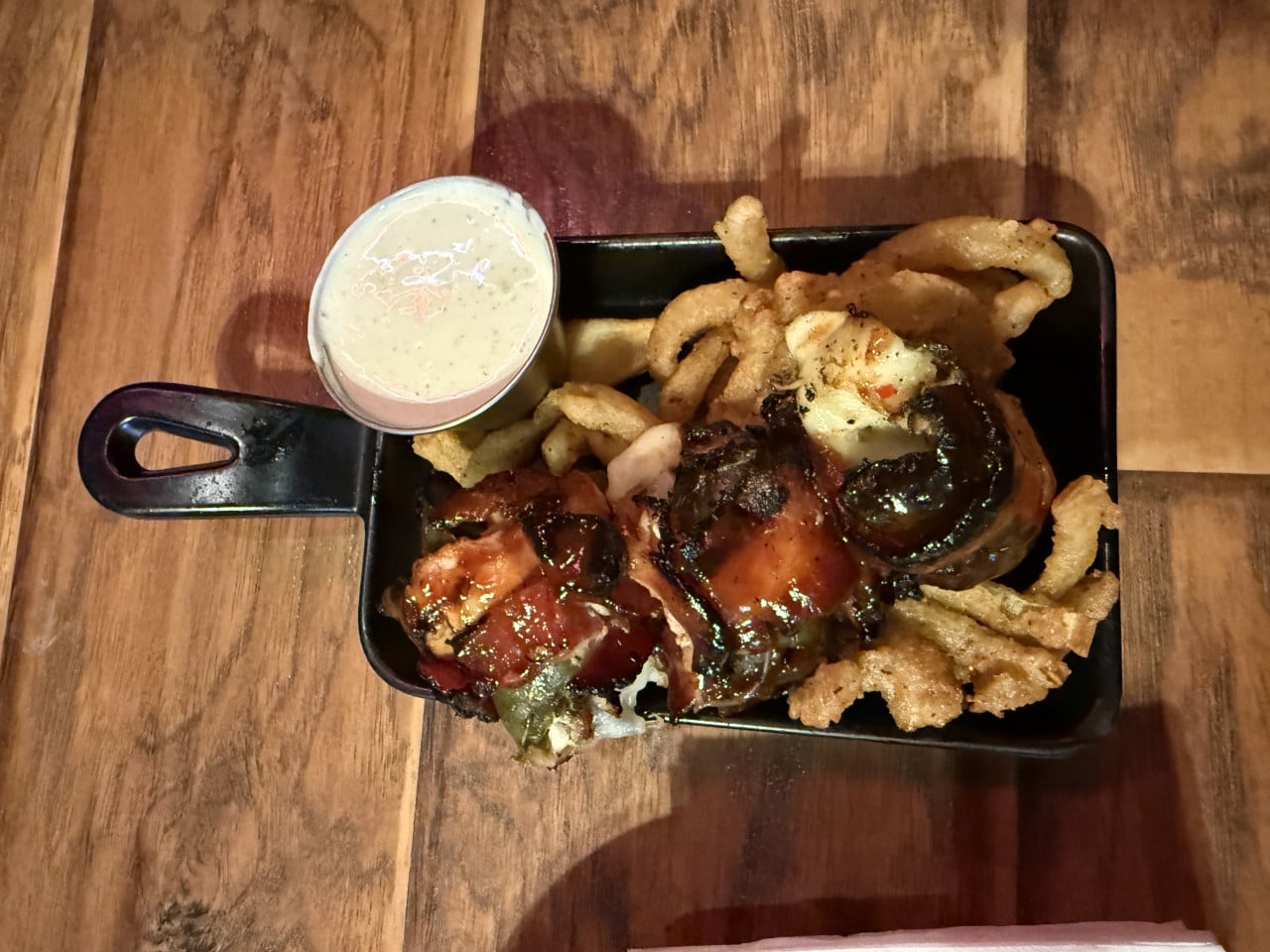 Litinová pánvička s BBQ masem, hranolky, kroužky a kelímek omáčky