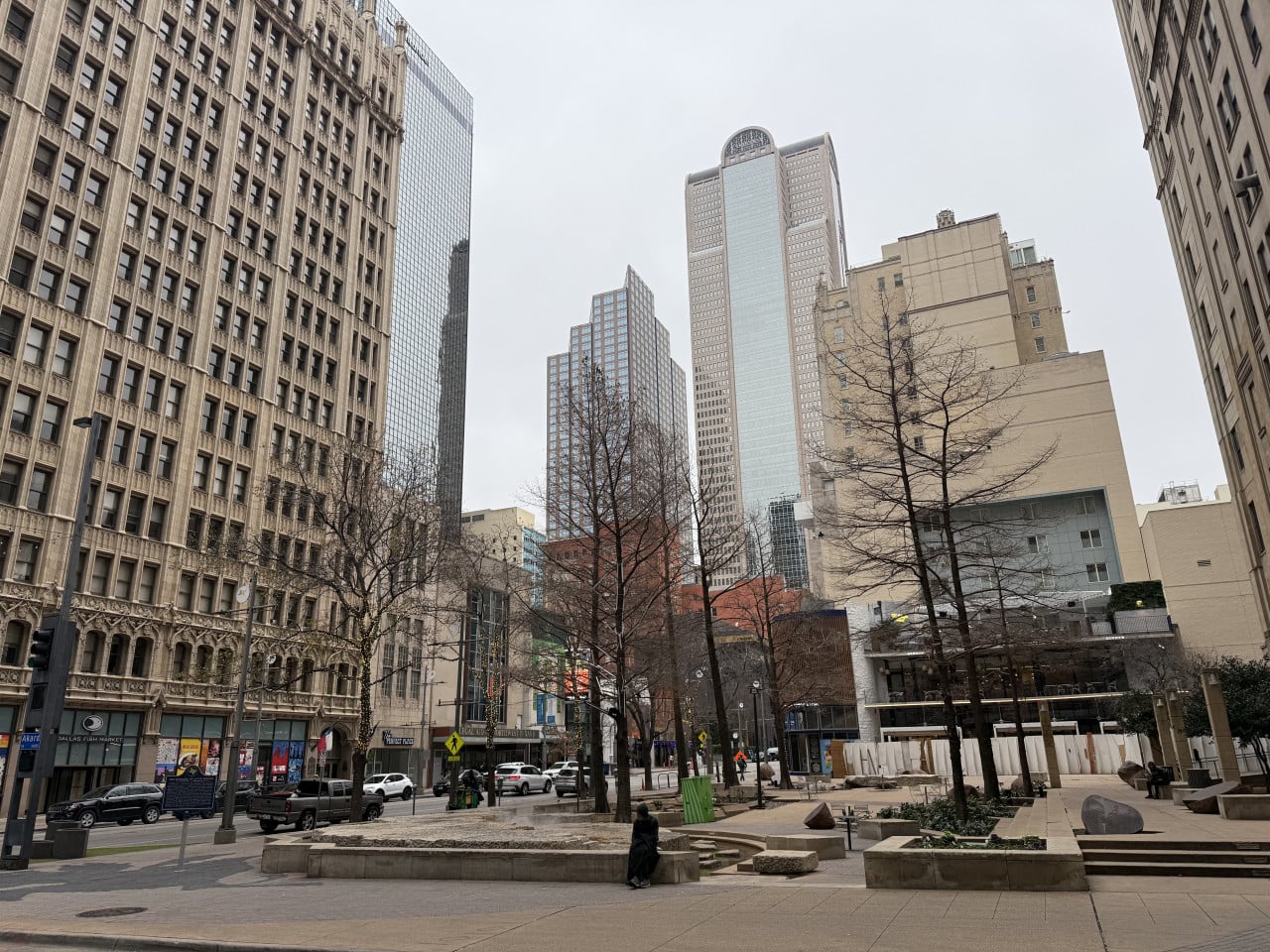 Náměstí v Downtown Dallas, mrakodrapy, holé stromy, auta a nápis Dallas Fish Market.