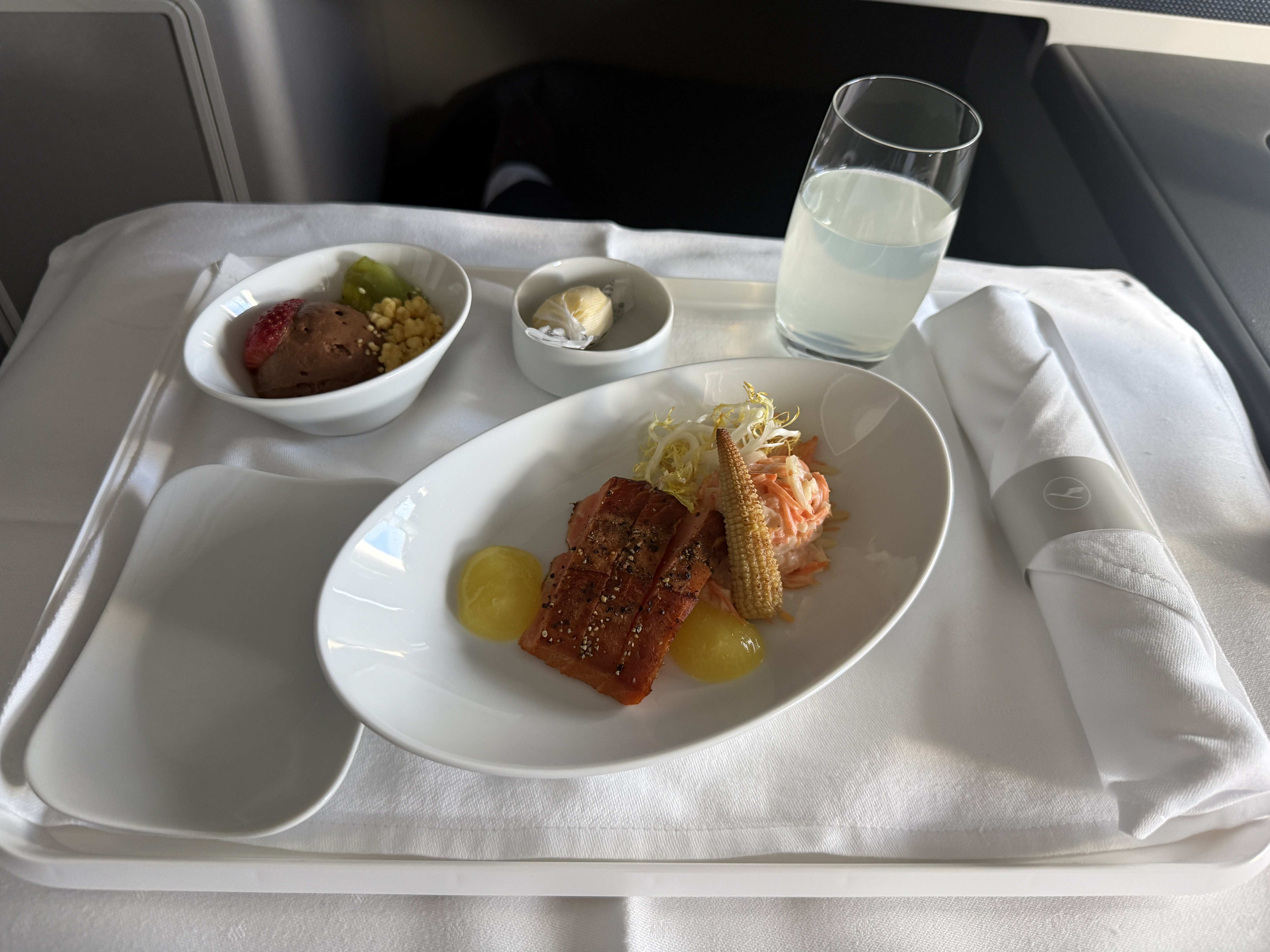 Jídlo v business class: losos se salátem, dezert, máslo a sklenice limonády.