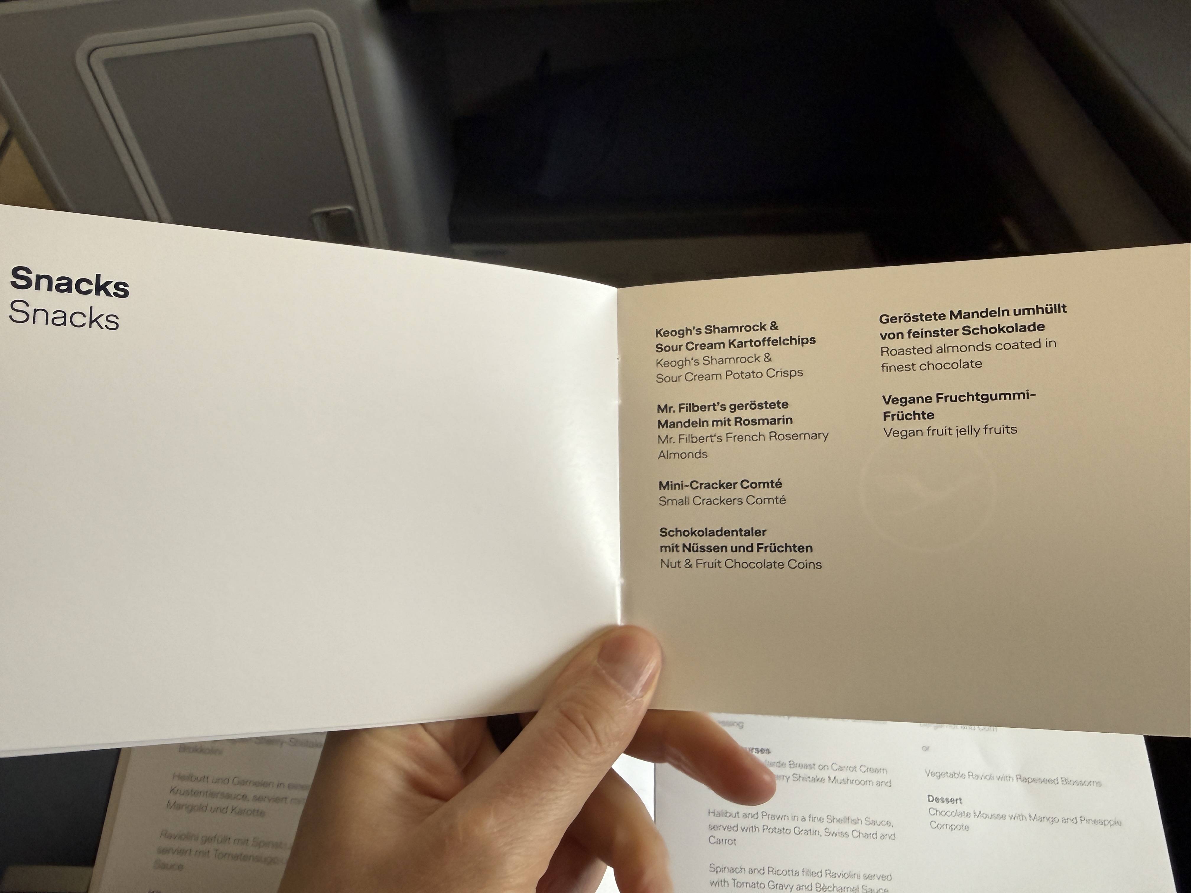 Otevřený palubní jídelní lístek Lufthansa, stránka Snacks se seznamem občerstvení
