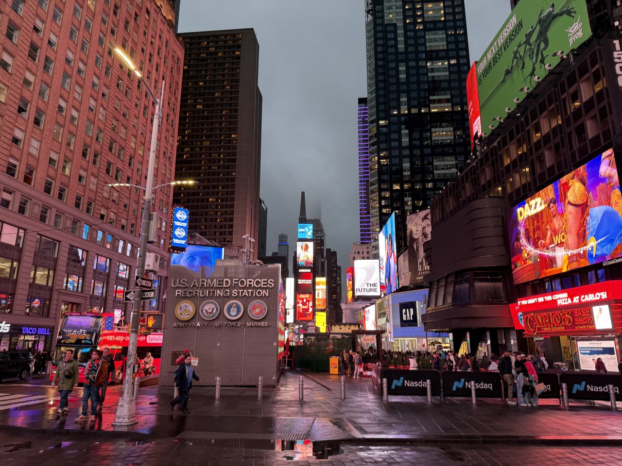 Times Square za soumraku s reklamními panely, lidmi a nápisem U.S. Armed Forces Recruiting Station