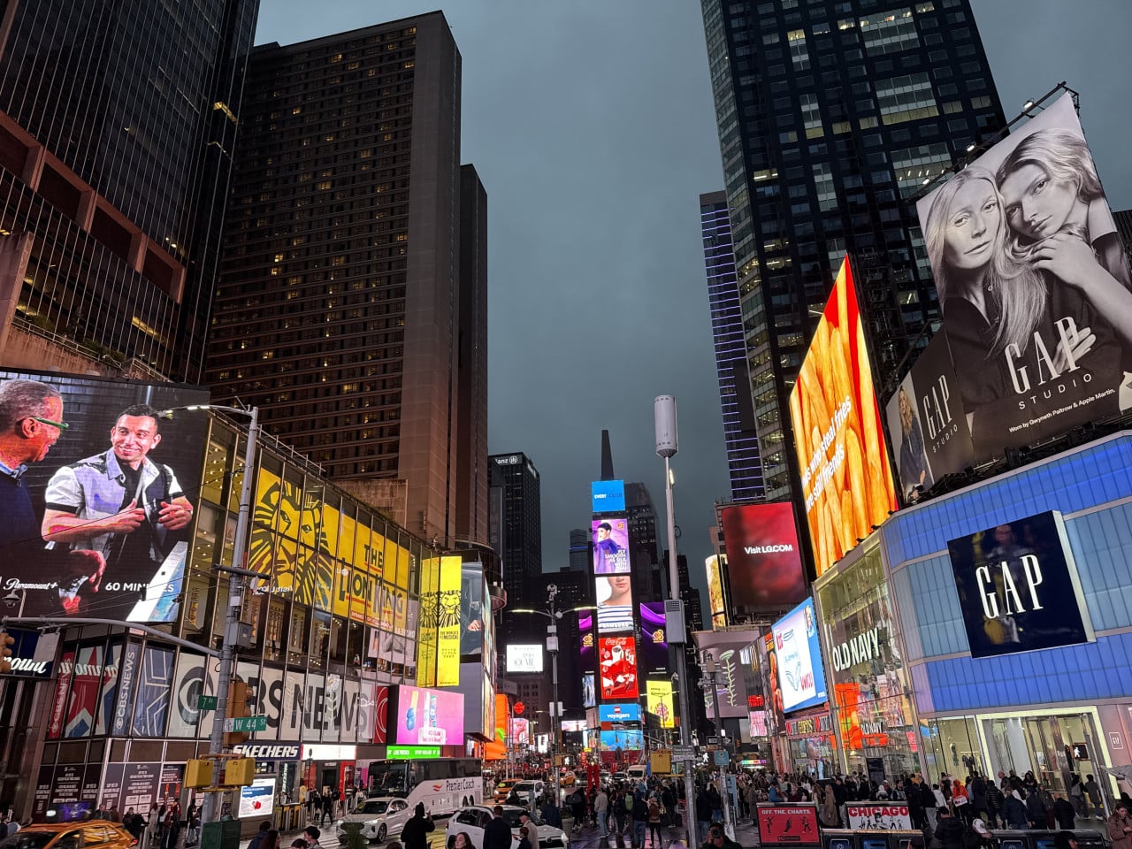 Večerní Times Square s barevnými billboardy a rušným provozem v New Yorku