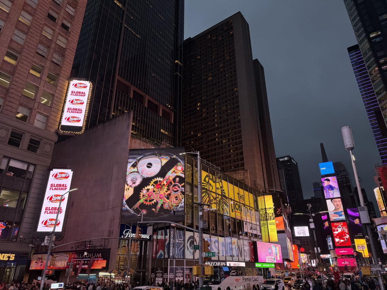 Večerní Times Square s mrakodrapy a jasnými reklamními billboardy.