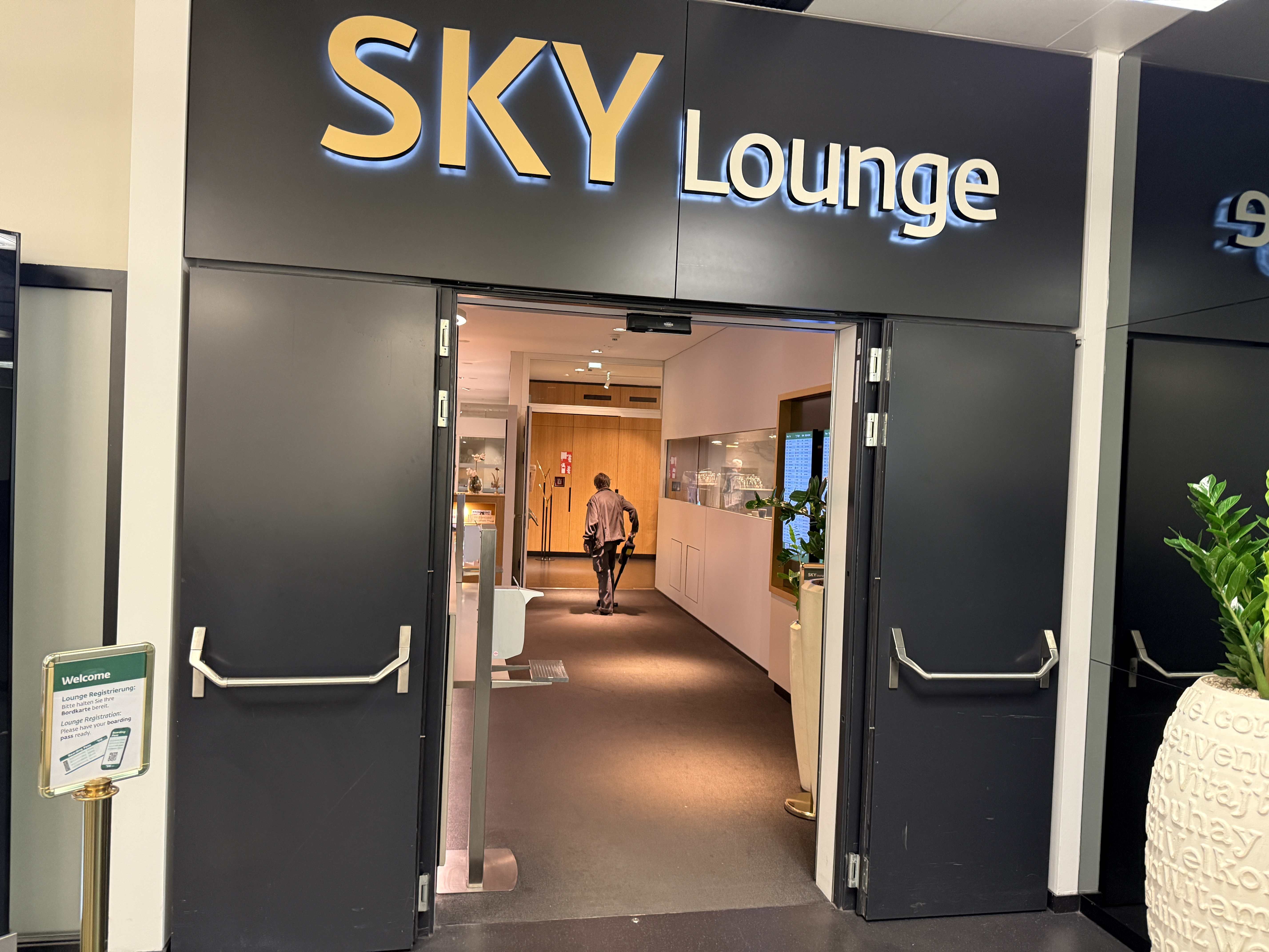 Vstup do SKY Lounge, otevřené dveře a muž kráčející dovnitř
