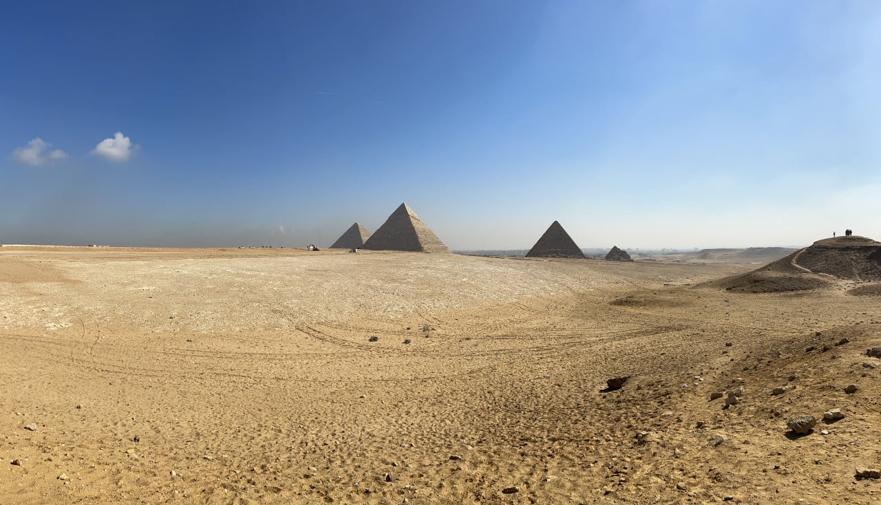 Pohled na pyramidy v Gíze včetně Cheopsovy pyramidy pod modrou oblohou