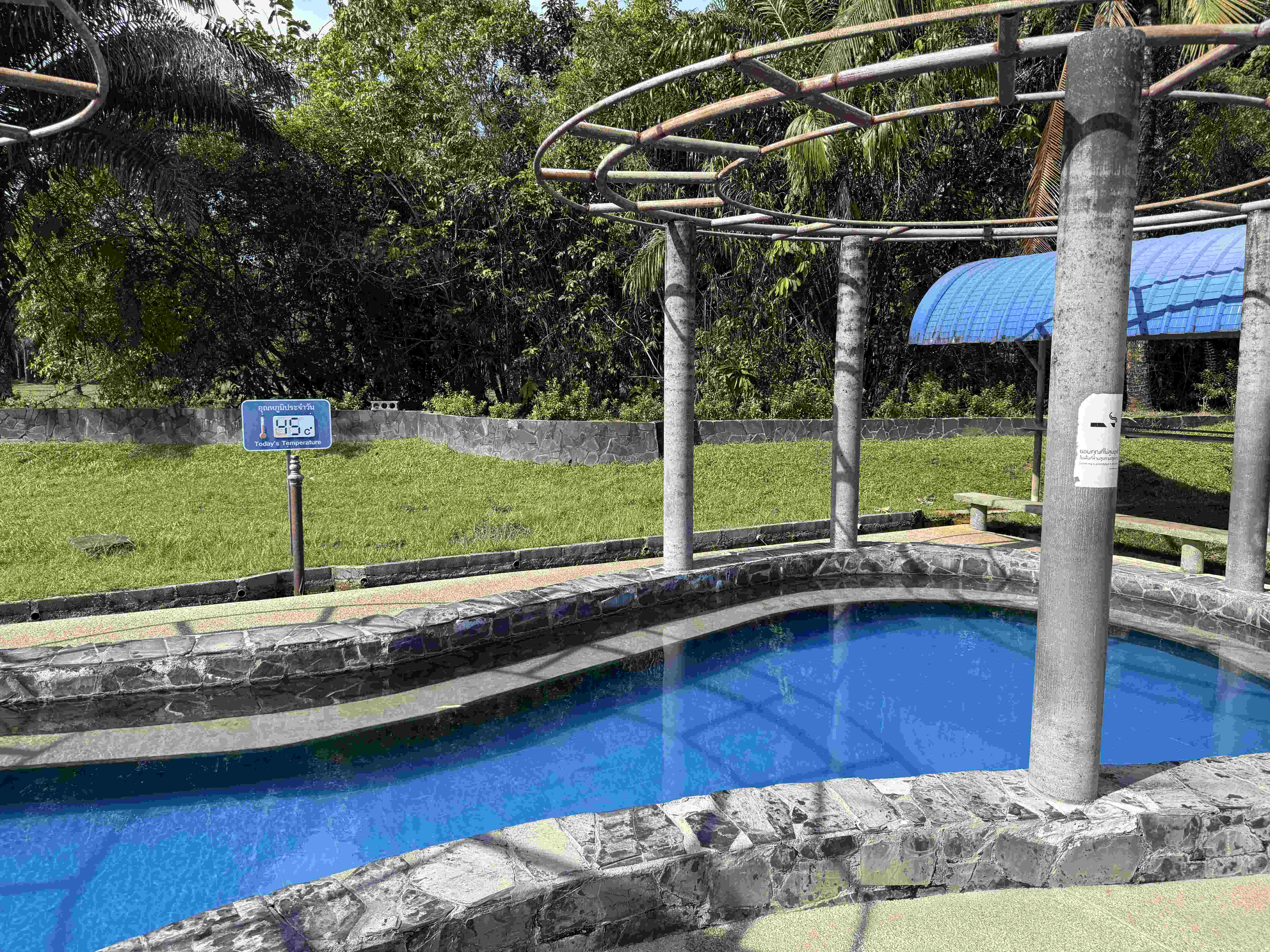 Modrý bazén v Rommanee Hot Spring, cedule Today's Temperature 49°C, tropická zeleň