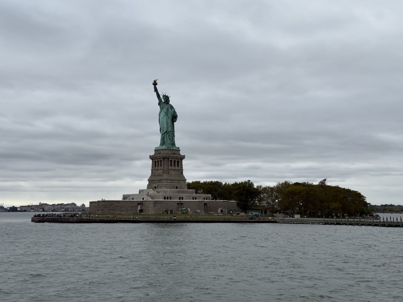 Socha Svobody na ostrově Liberty Island, pohled z vody pod zataženou oblohou
