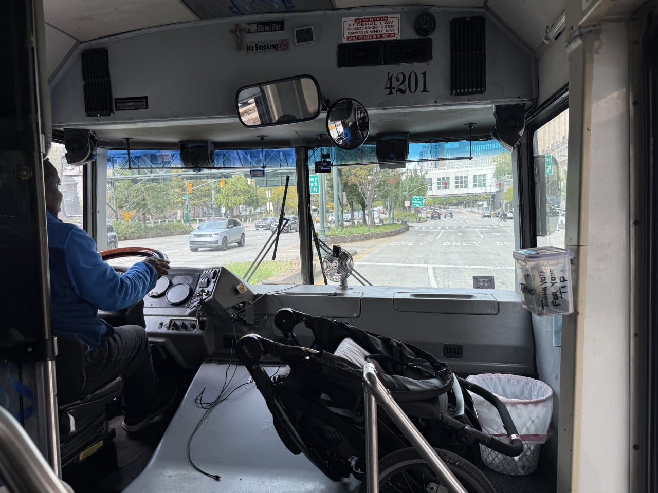 Pohled z autobusu na řidiče, silnici a dopravní značky v New Yorku