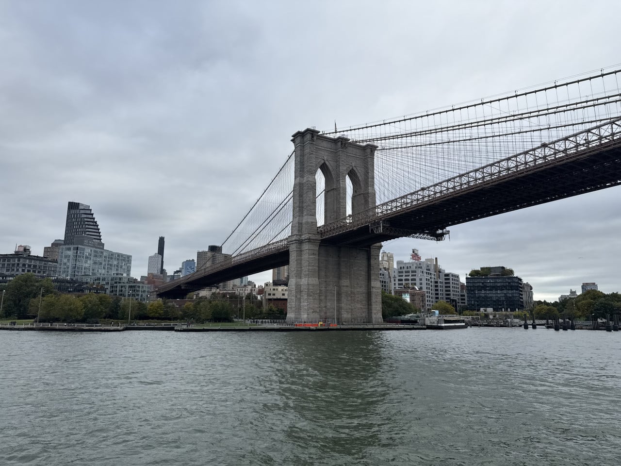 Brooklyn Bridge nad řekou East River s newyorským panoramatem v pozadí
