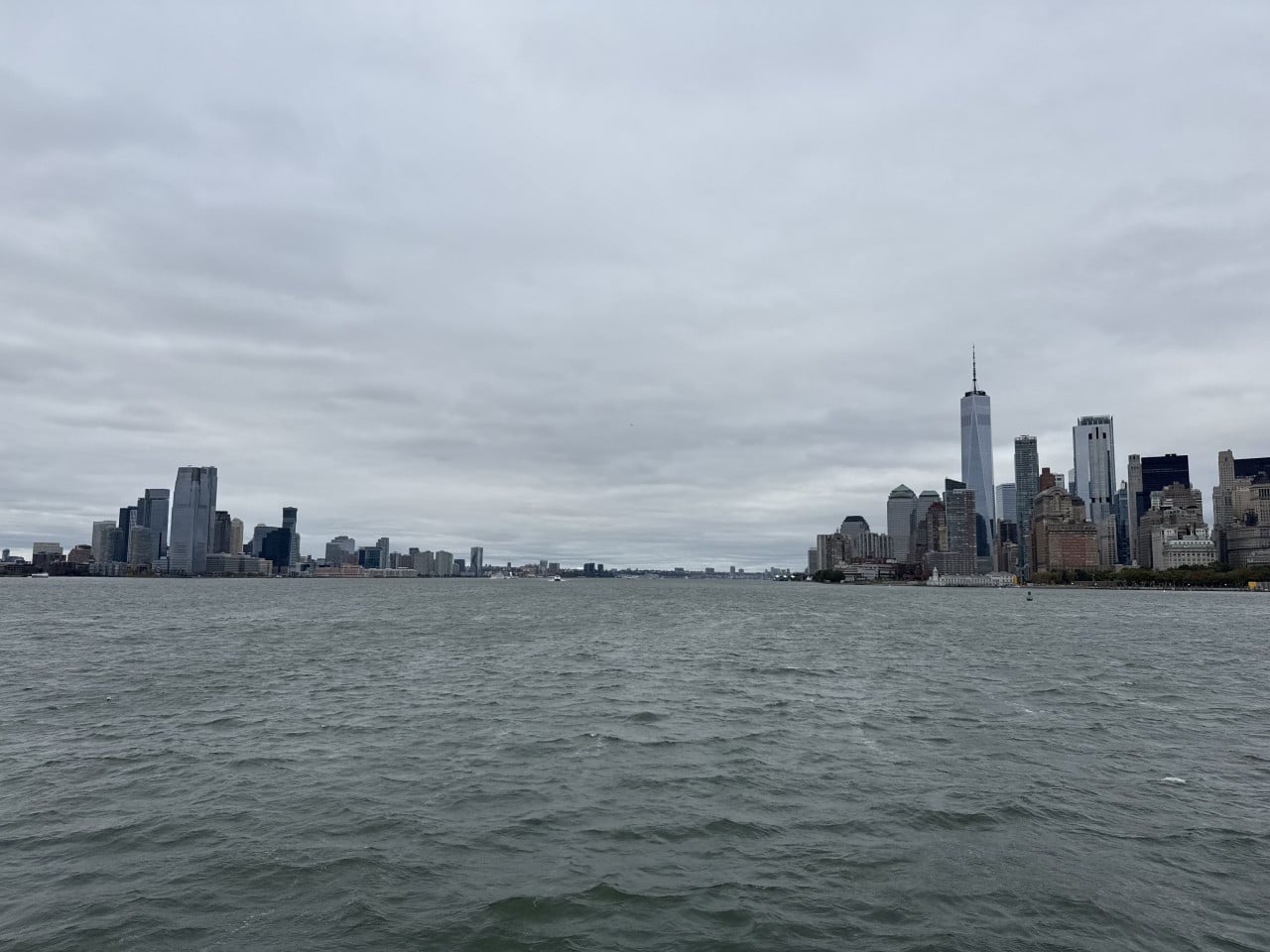 Panorama newyorského přístavu a skyline Manhattanu pod zataženou oblohou