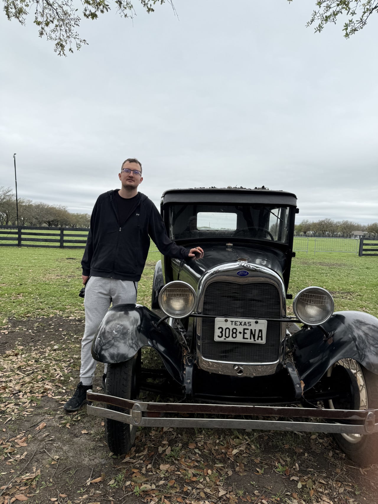 Muž u černého veteránu s SPZ TEXAS 308-ENA na ranči