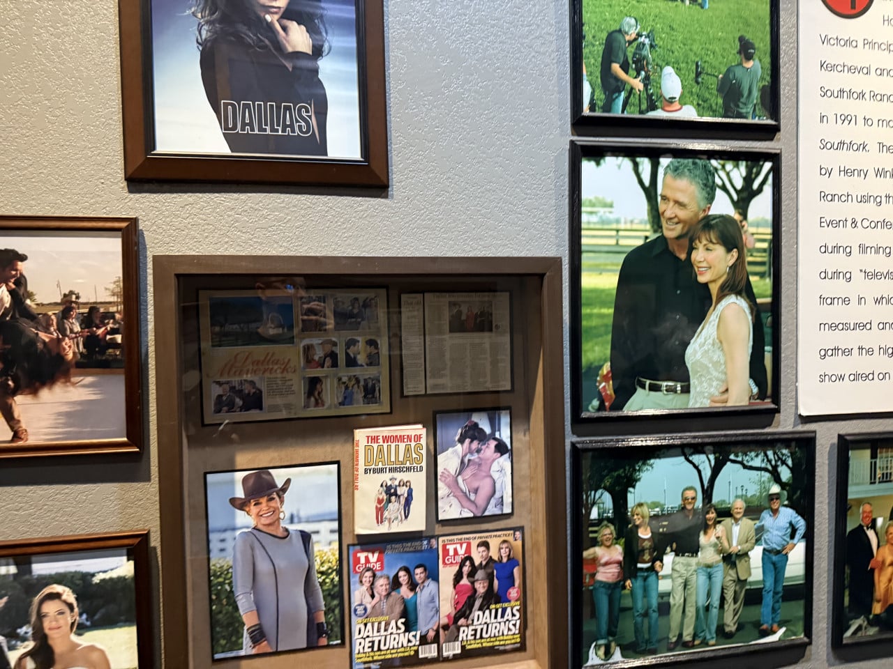 Stěna s rámy a memorabiliemi seriálu Dallas, nápisy DALLAS, TV Guide, THE WOMEN OF DALLAS