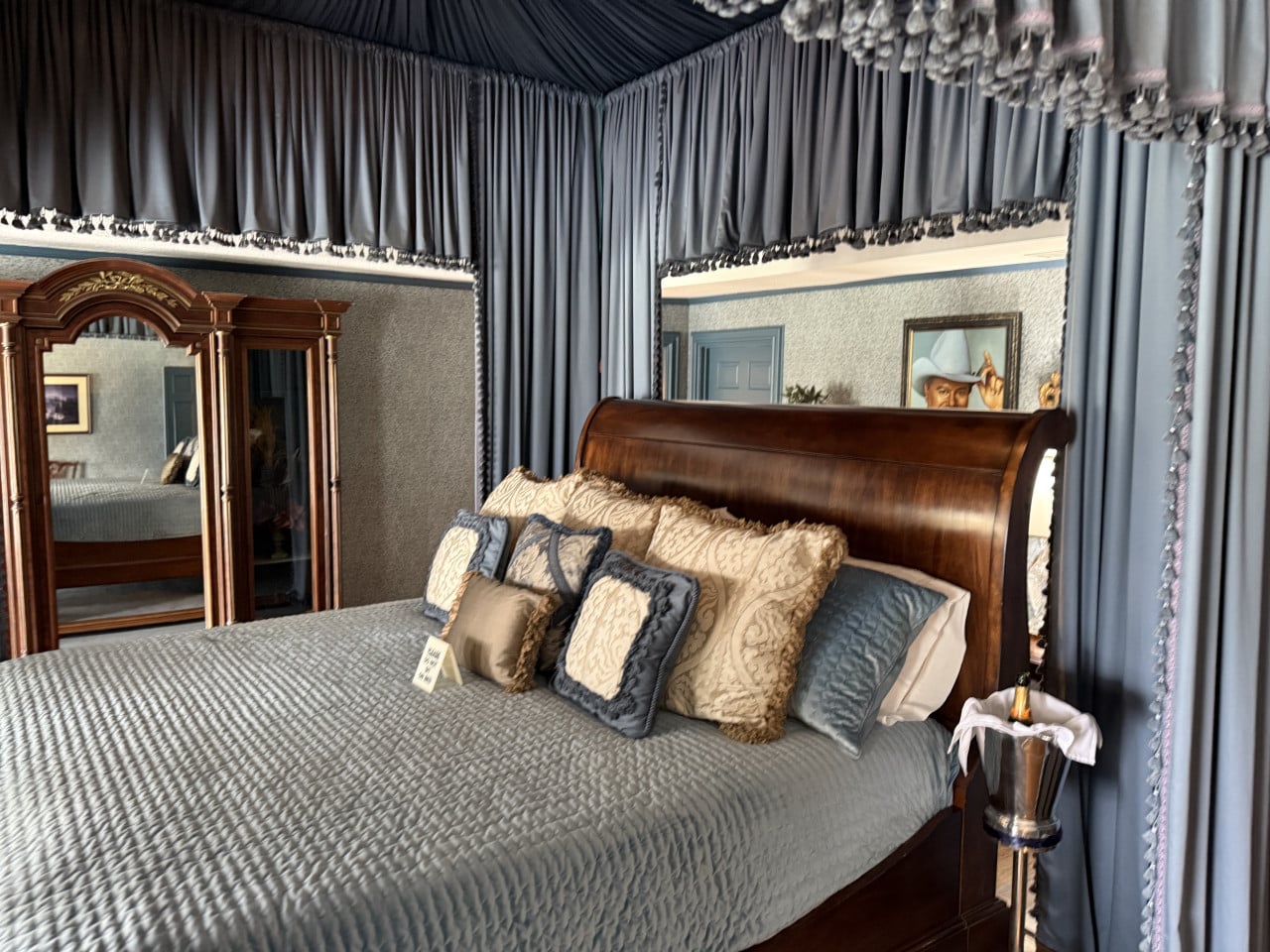 Ložnice na Southfork Ranch: velká dřevěná postel s baldachýnem, polštáře, šampaňské.