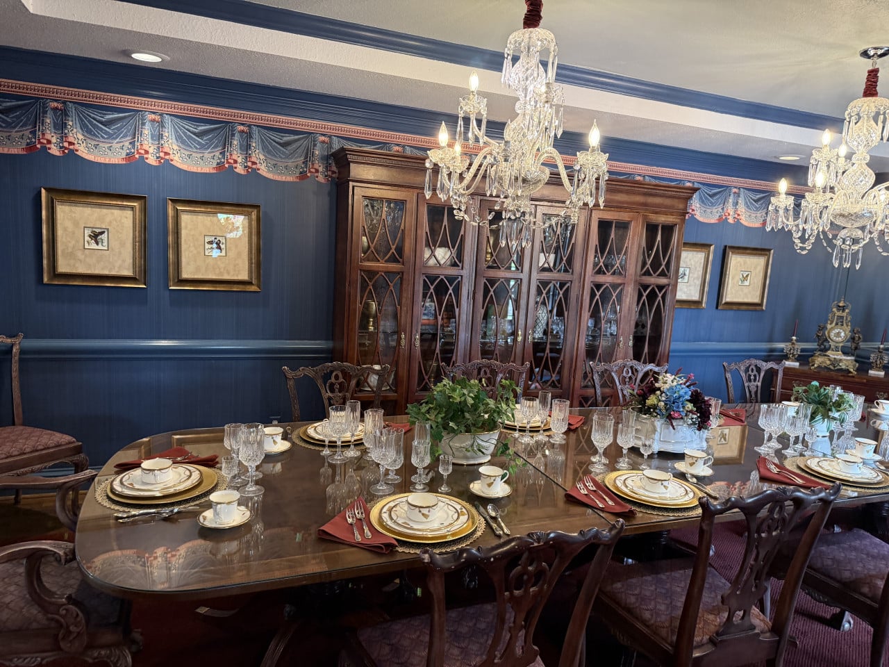 Jídelna na Southfork Ranch: prostřený dlouhý stůl, lustry a vitrína