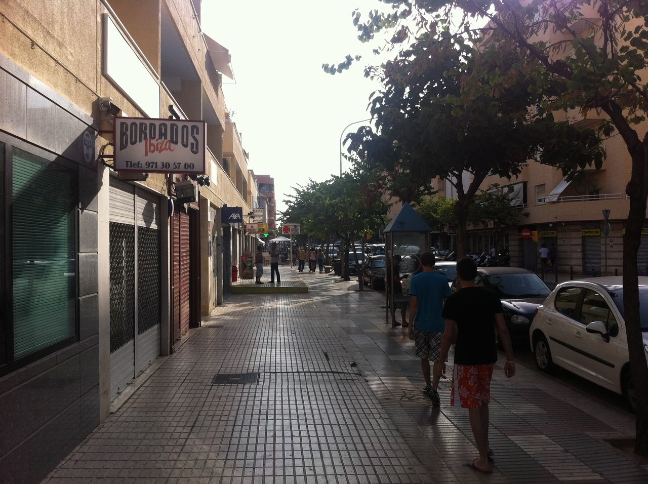 Ulice na Ibize, dva muži na chodníku, cedule BORDADOS Ibiza Tel: 971 30 57 00.