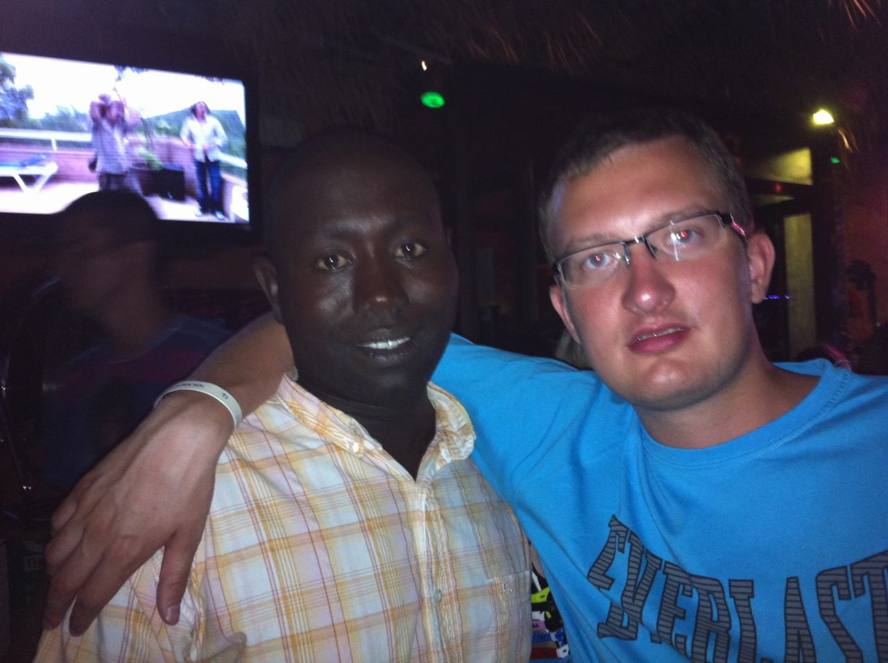 Dva muži v nočním klubu, jeden v tričku AEROPOSTALE objímá druhého.