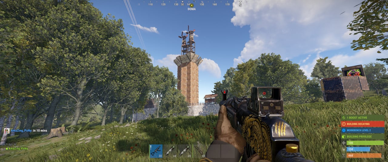 Pohled z Rustu na věž, stromový les, pušku v ruce a HUD s BUILDING DECAYING.