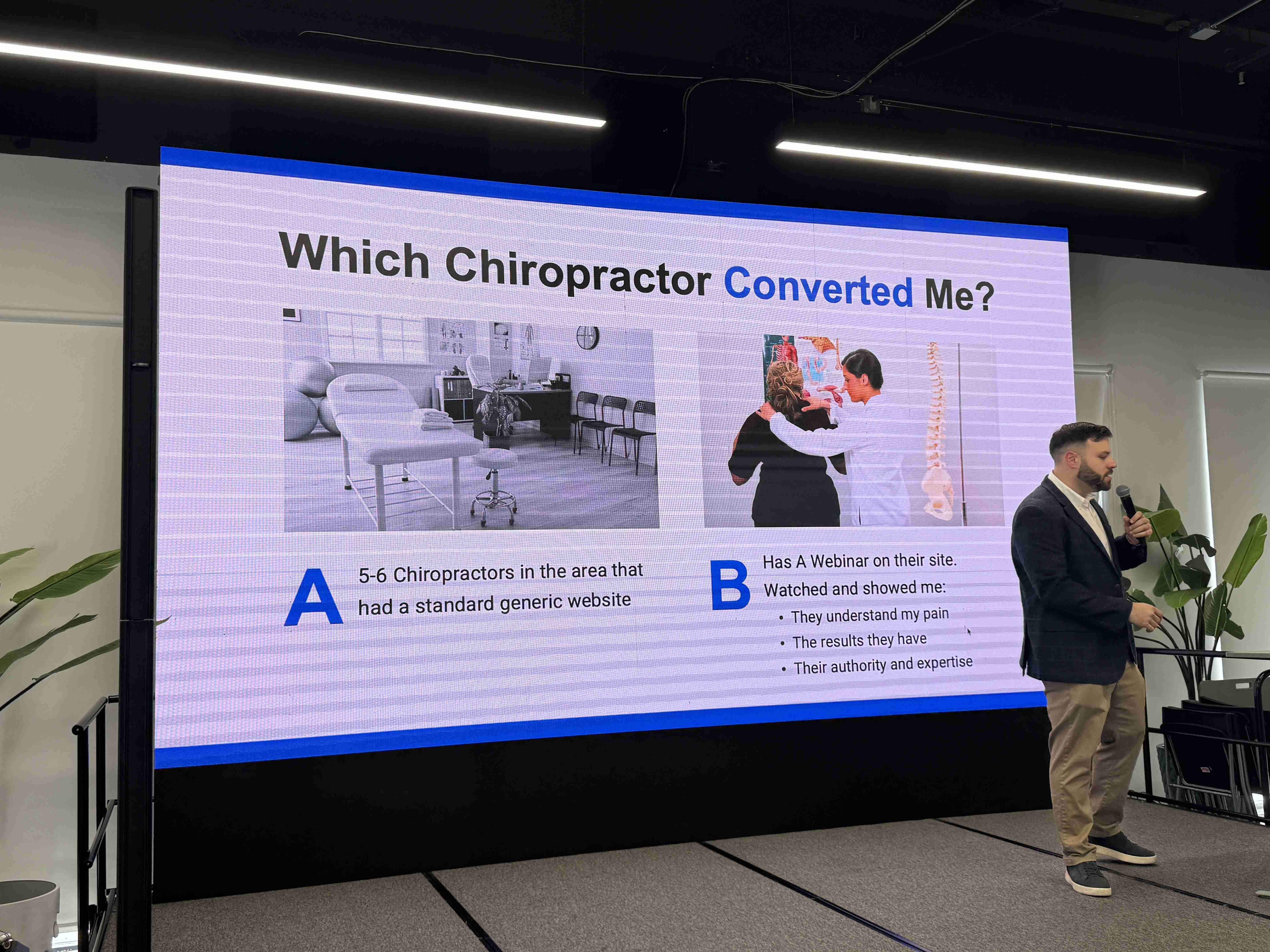 Přednášející s mikrofonem u obrazovky se slidem Which Chiropractor Converted Me?