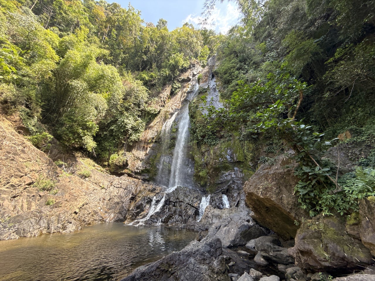 Vodopád Tam Nang padá ze skály do přírodního jezírka uprostřed džungle