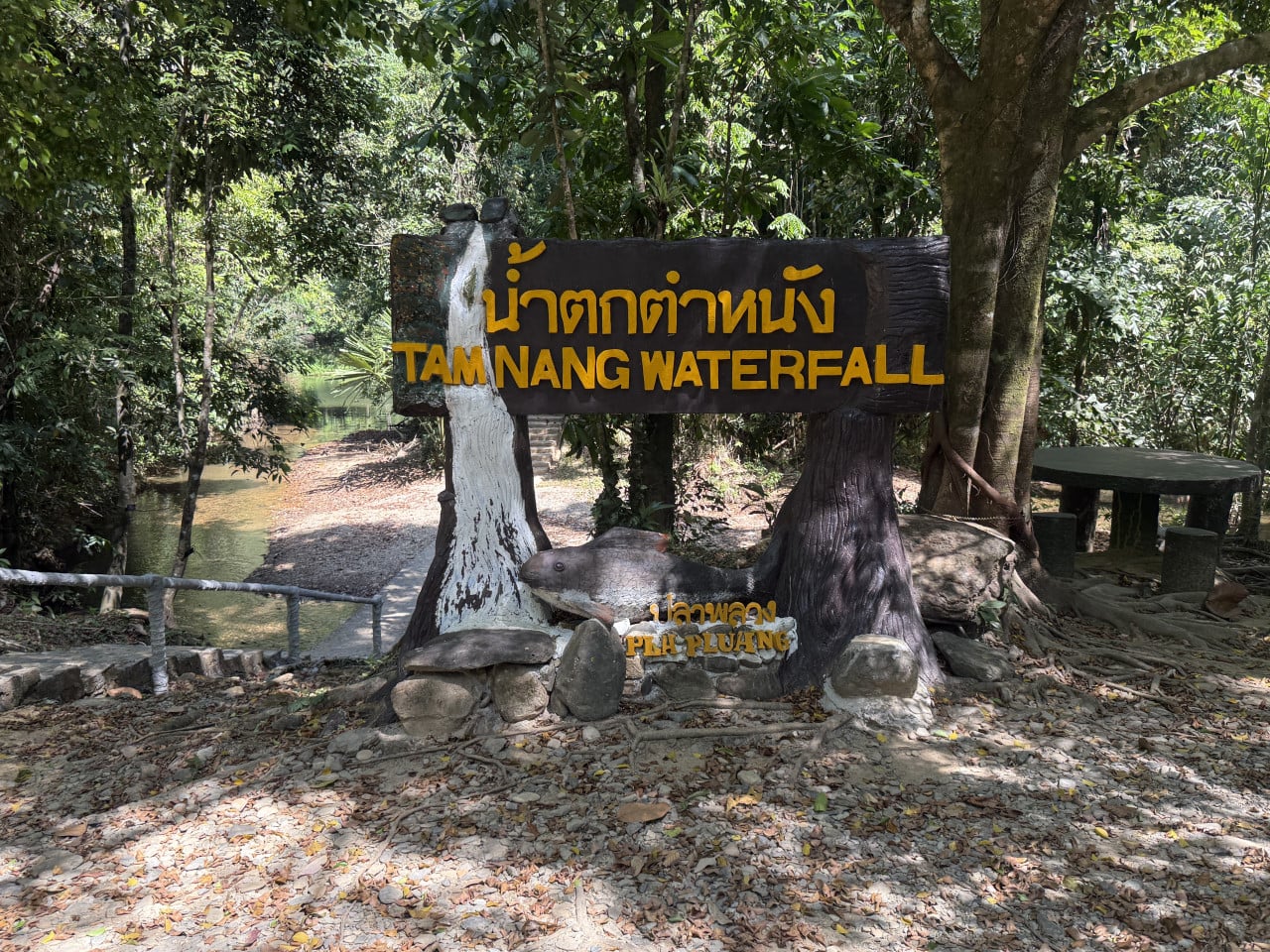 Dřevěná cedule s nápisem TAM NANG WATERFALL a PLA PLUANG v džungli