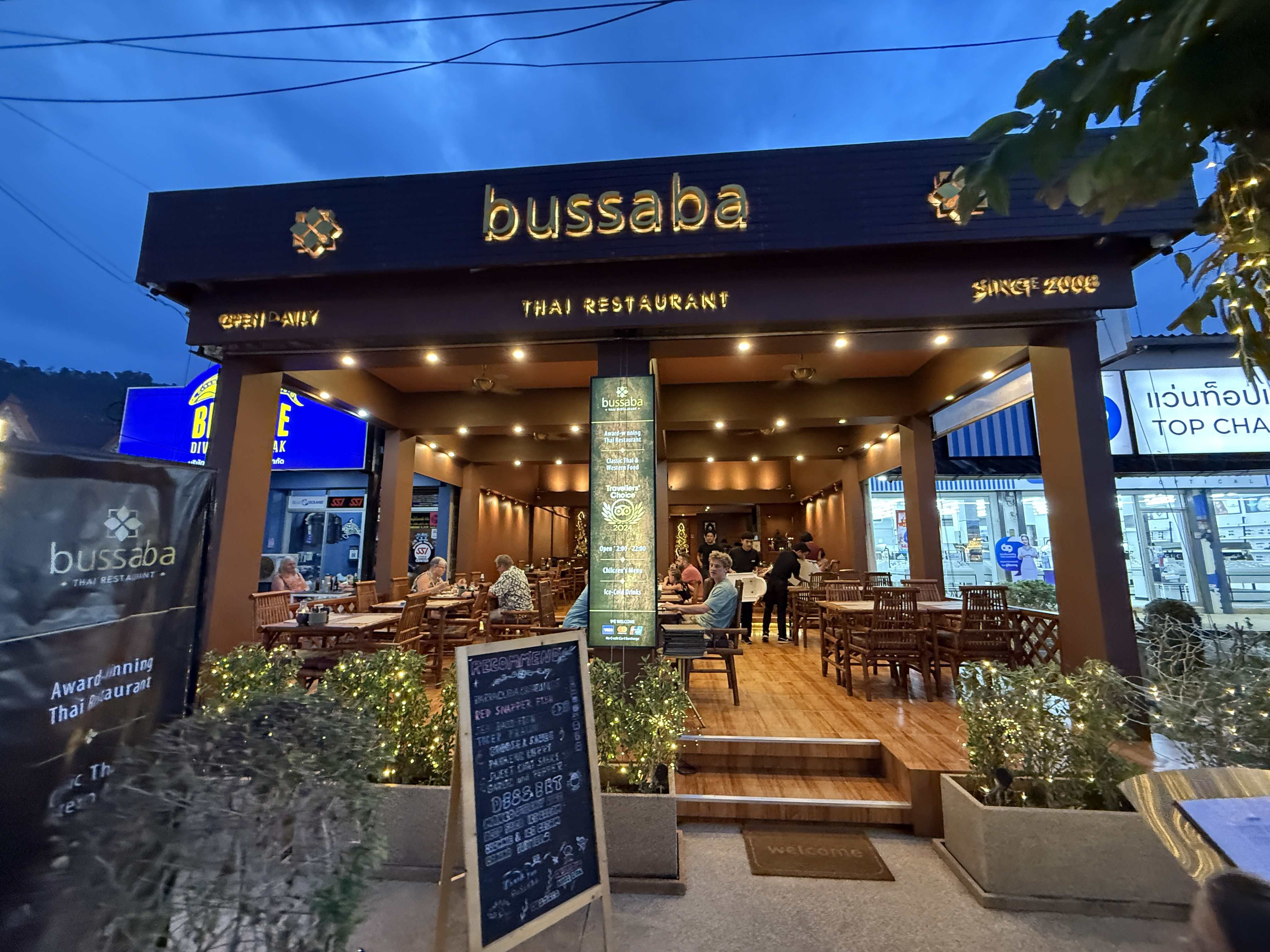 Vchod do bussaba THAI RESTAURANT, OPEN DAILY, SINCE 2008, s venkovním posezením.
