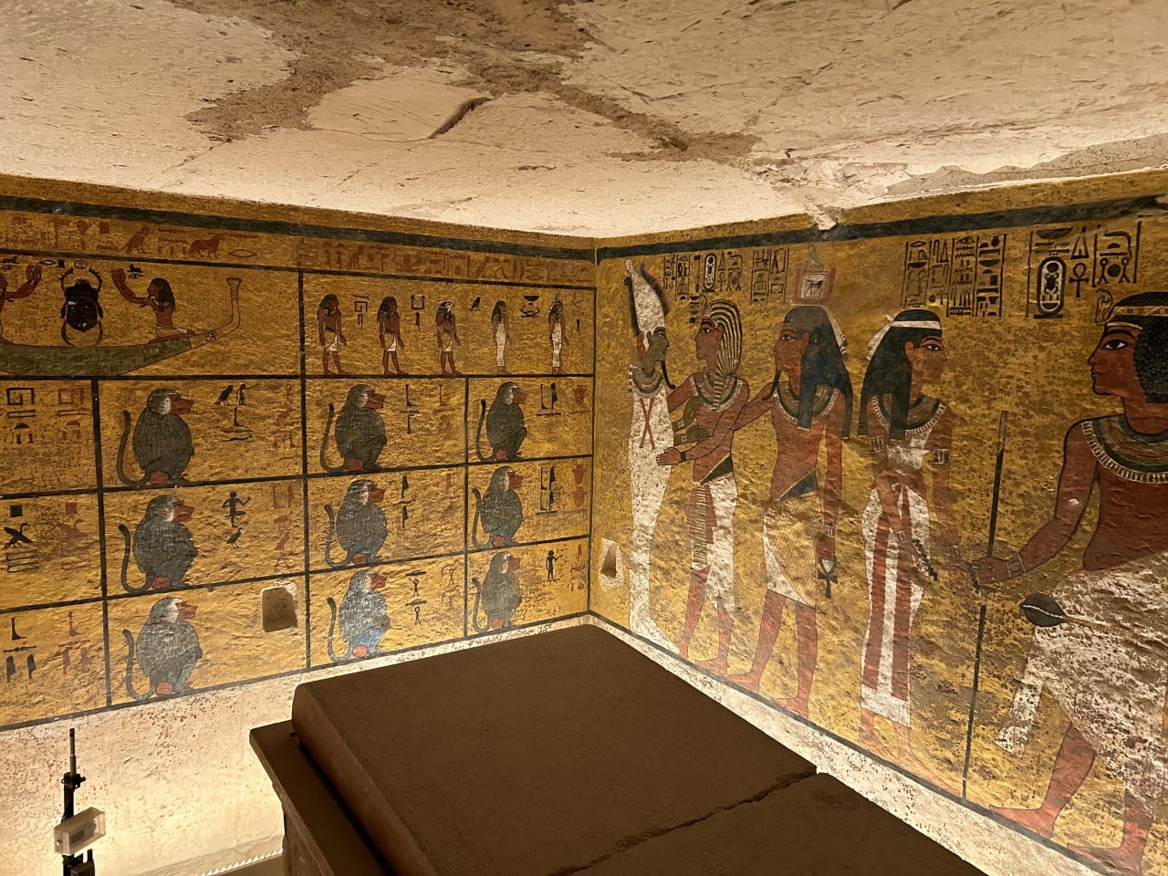 Barevná nástěnná malba v egyptské hrobce s hieroglyfy a postavami.