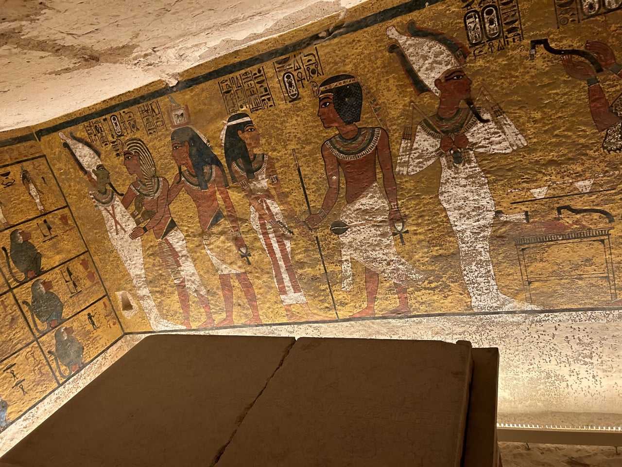 Barevná egyptská nástěnná malba s hieroglyfy v hrobce, detail stropu a sarkofágu.