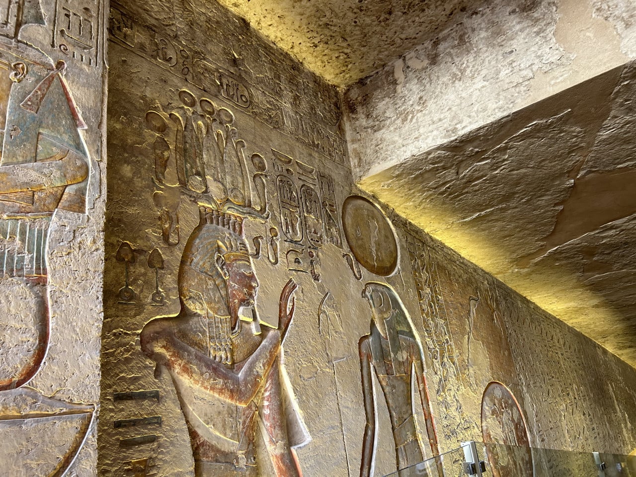 Barevné reliéfy a hieroglyfy na stěně staroegyptské hrobky v Údolí králů