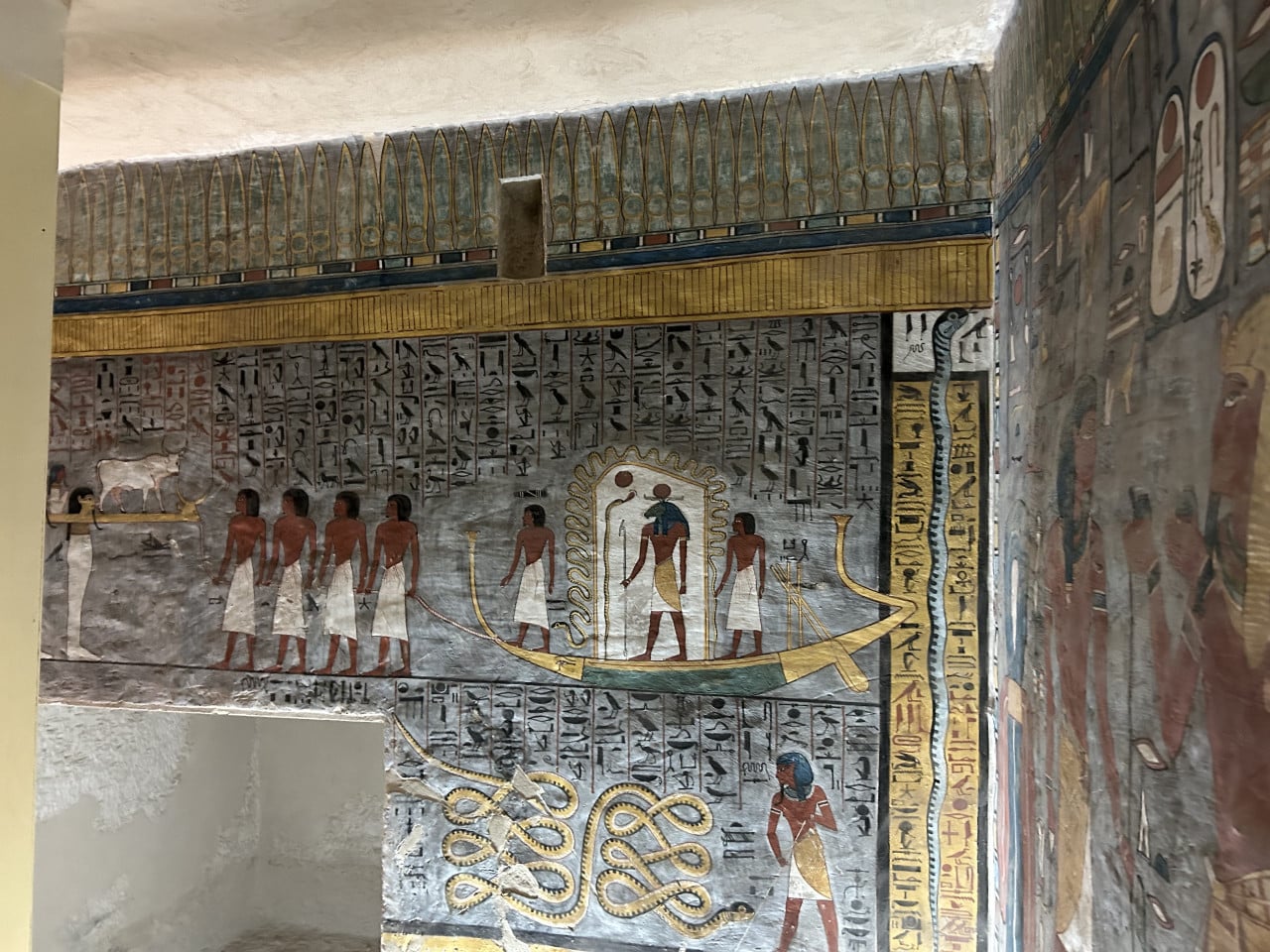 Barevné egyptské nástěnné malby s hieroglyfy a postavami v hrobce Tutanchamona
