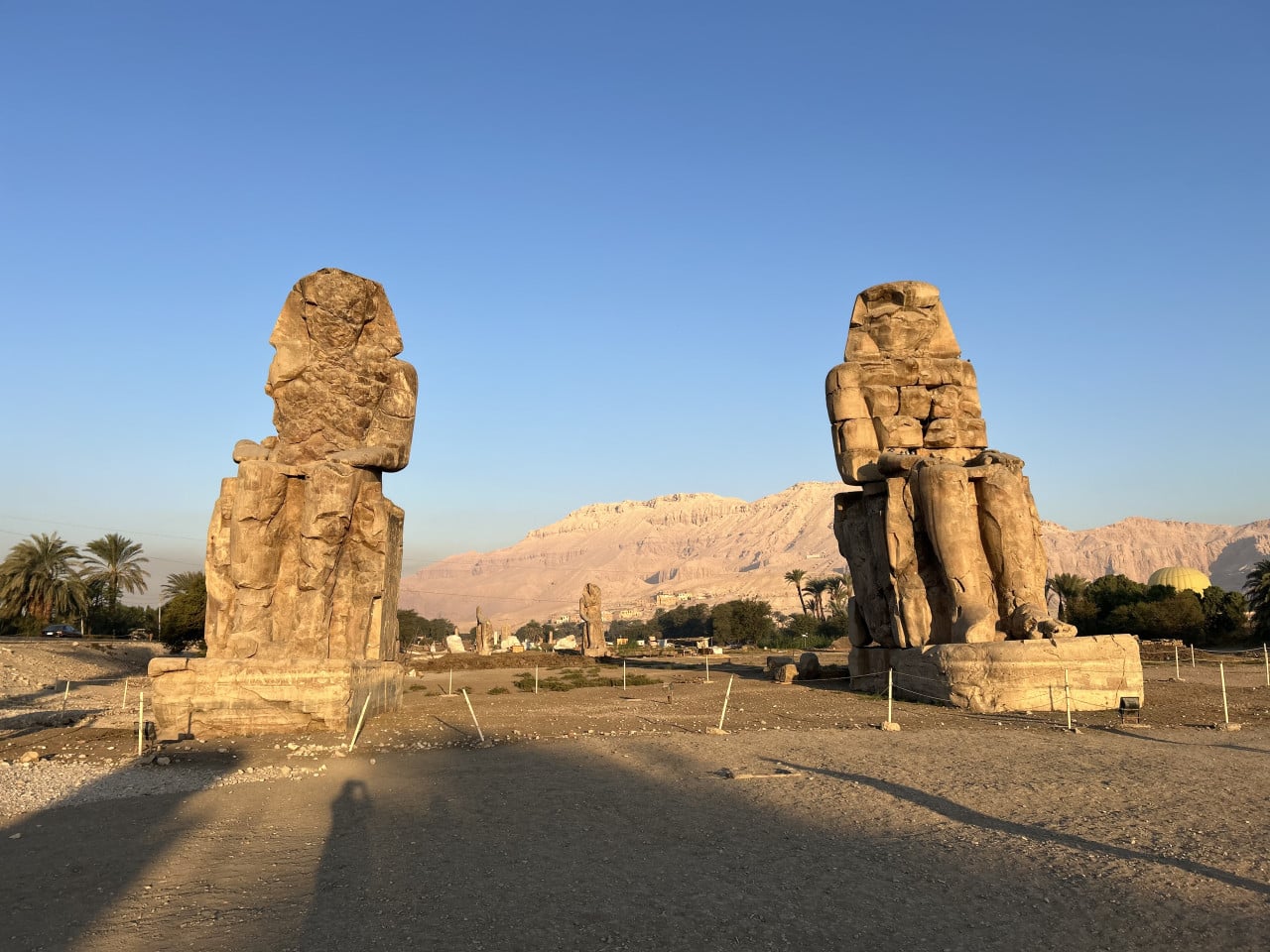 Kolosy Memnonovy so dvěma sedícími sochami v ranním světle, Luxor, Egypt
