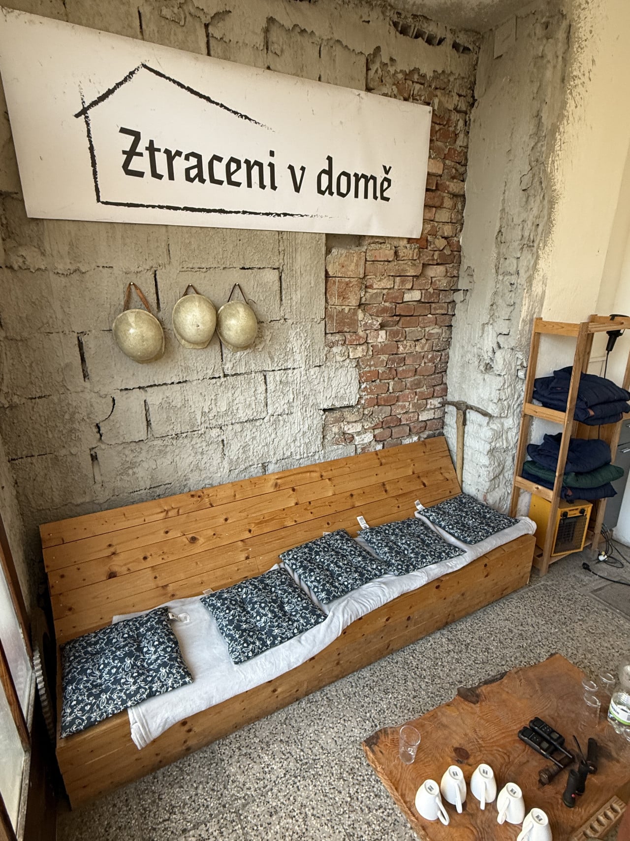 Interiér únikové hry s nápisem Ztraceni v domě, lůžkem a rekvizitami.