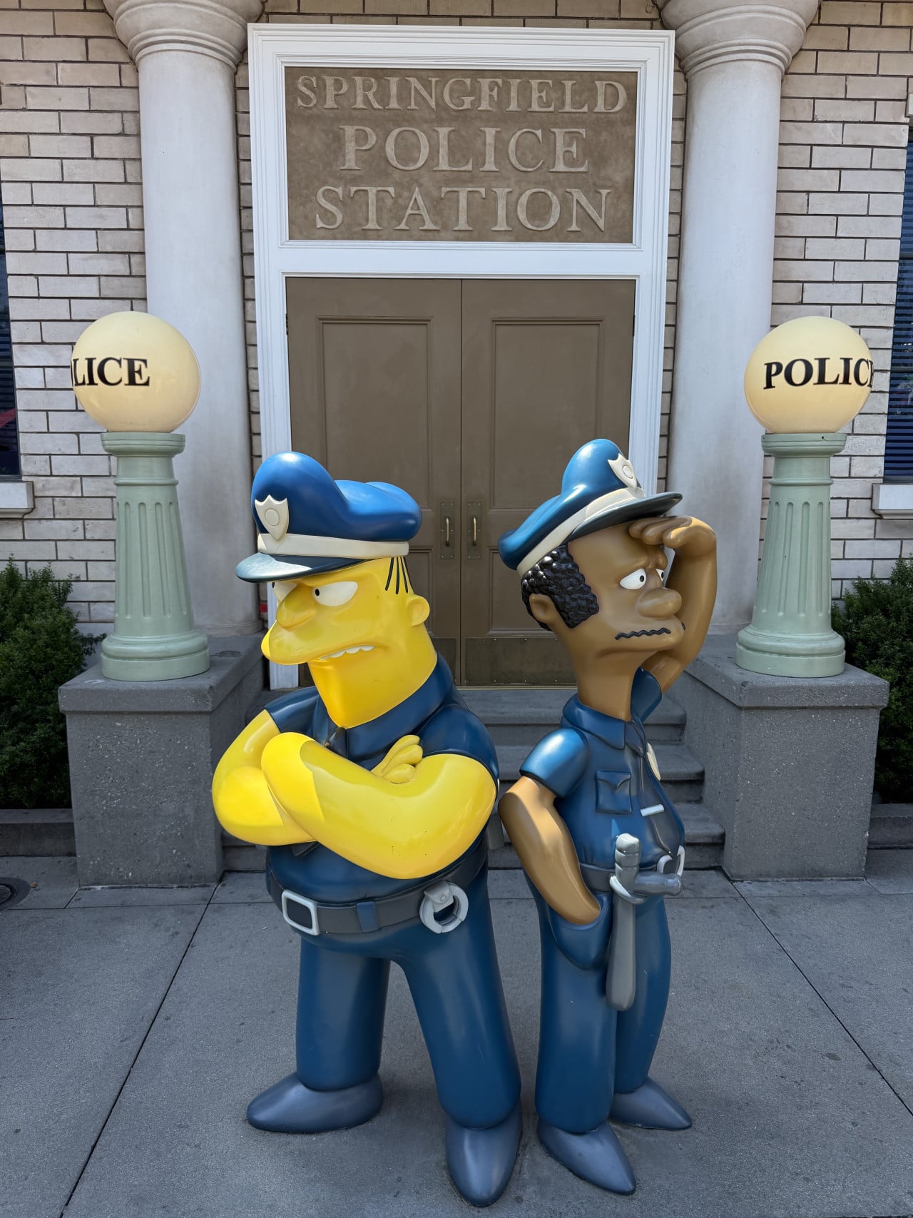 Sochy policejní stanice Springfield s postavami ze Simpsonových před dveřmi