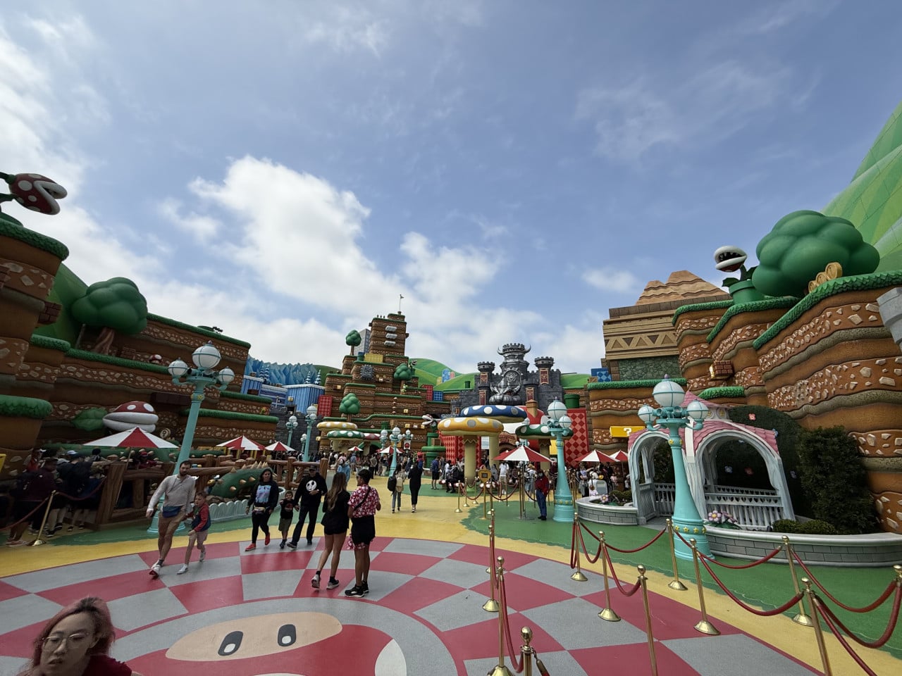 Barevná Super Nintendo World s návštěvníky a obřími houbami v Universal Studios Hollywood