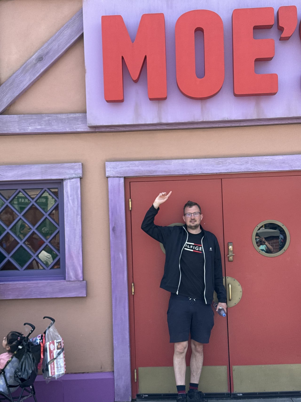 Muž stojí před červenými dveřmi a nápisem MOE’s v Universal Studios Hollywood