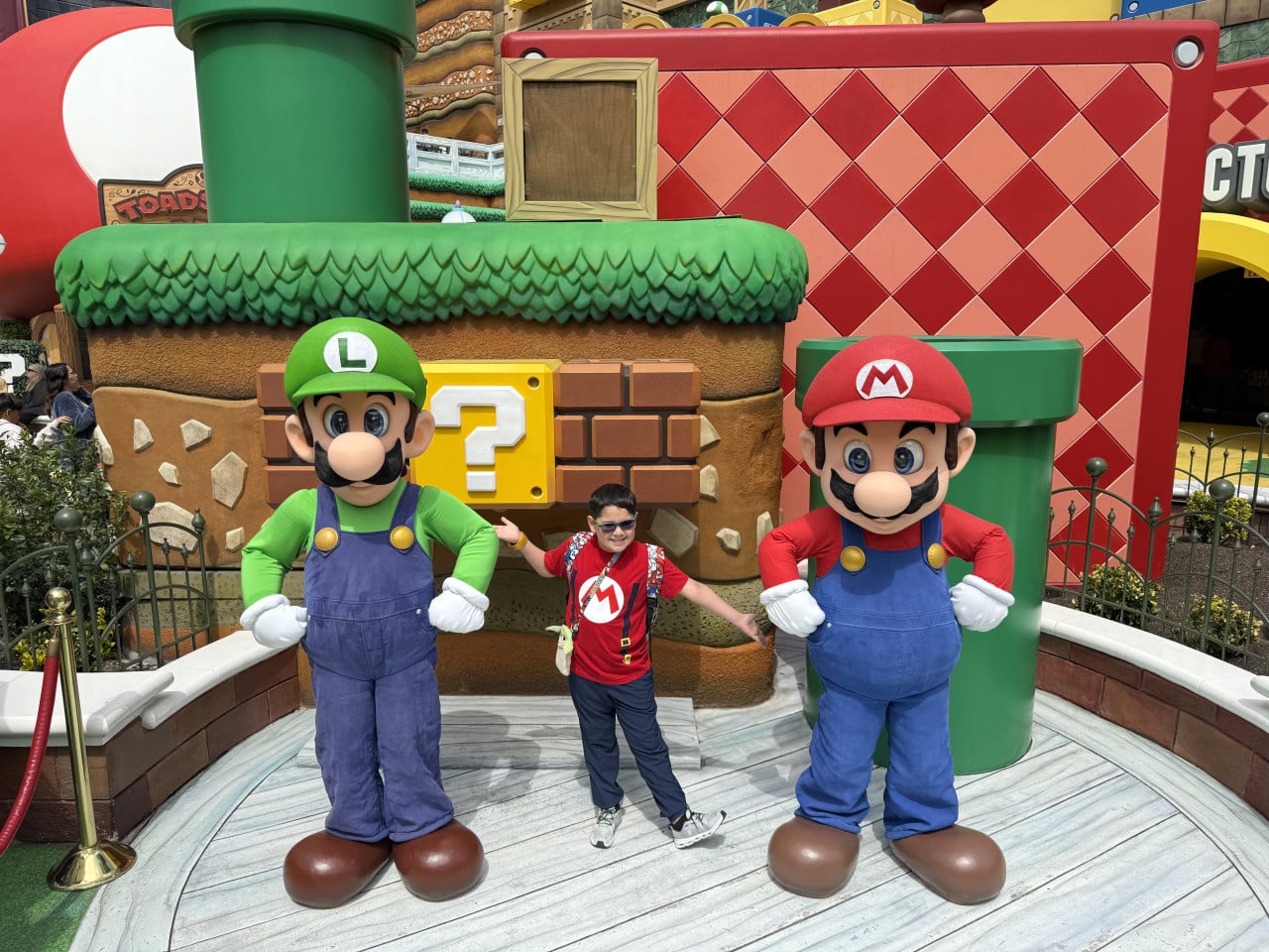 Chlapec mezi postavami Luigiho a Maria v Super Mario atrakci Universal Studios Harry?