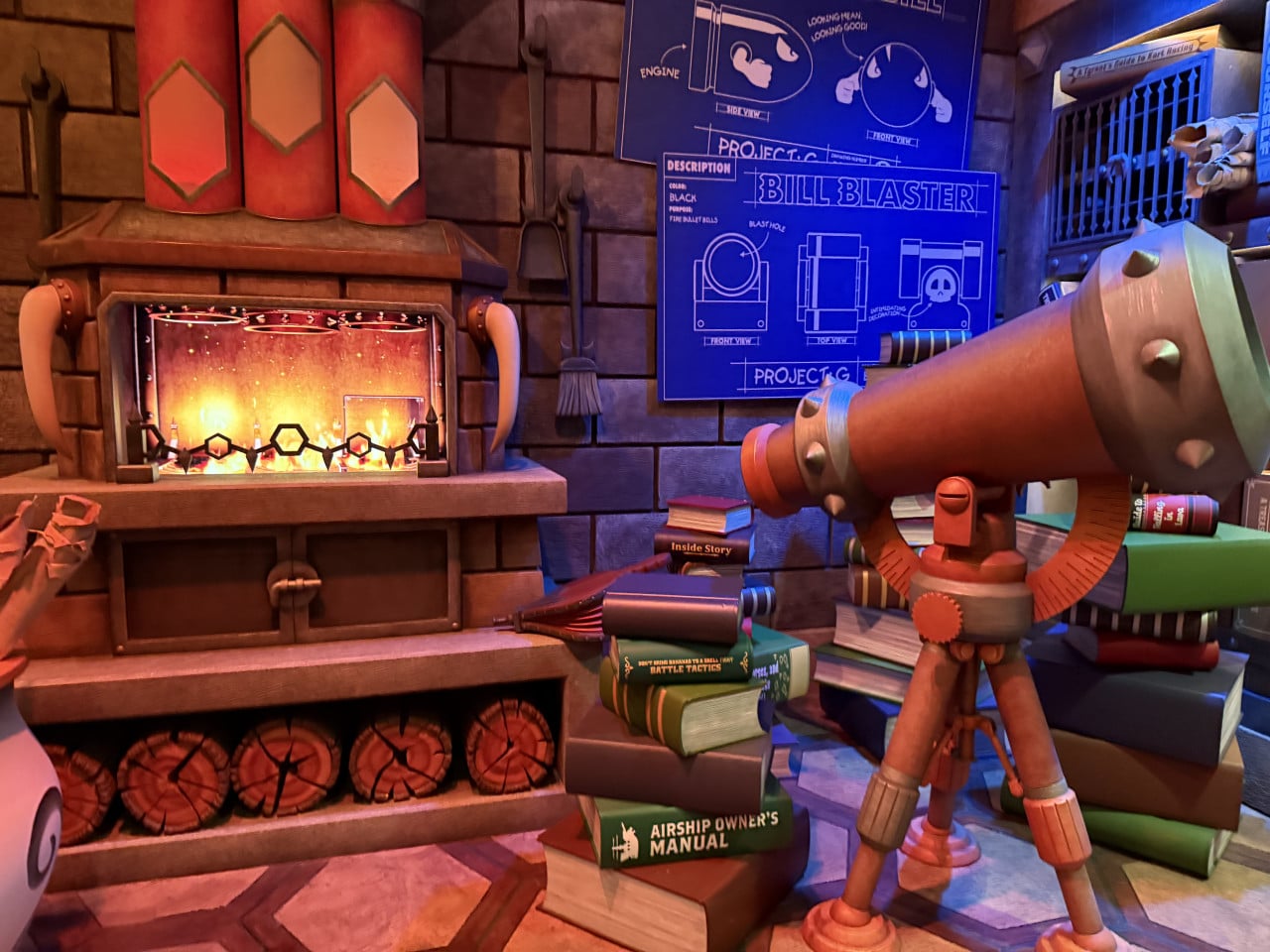 Tematická místnost s krbem, dělem a plány s nápisem BILL BLASTER.
