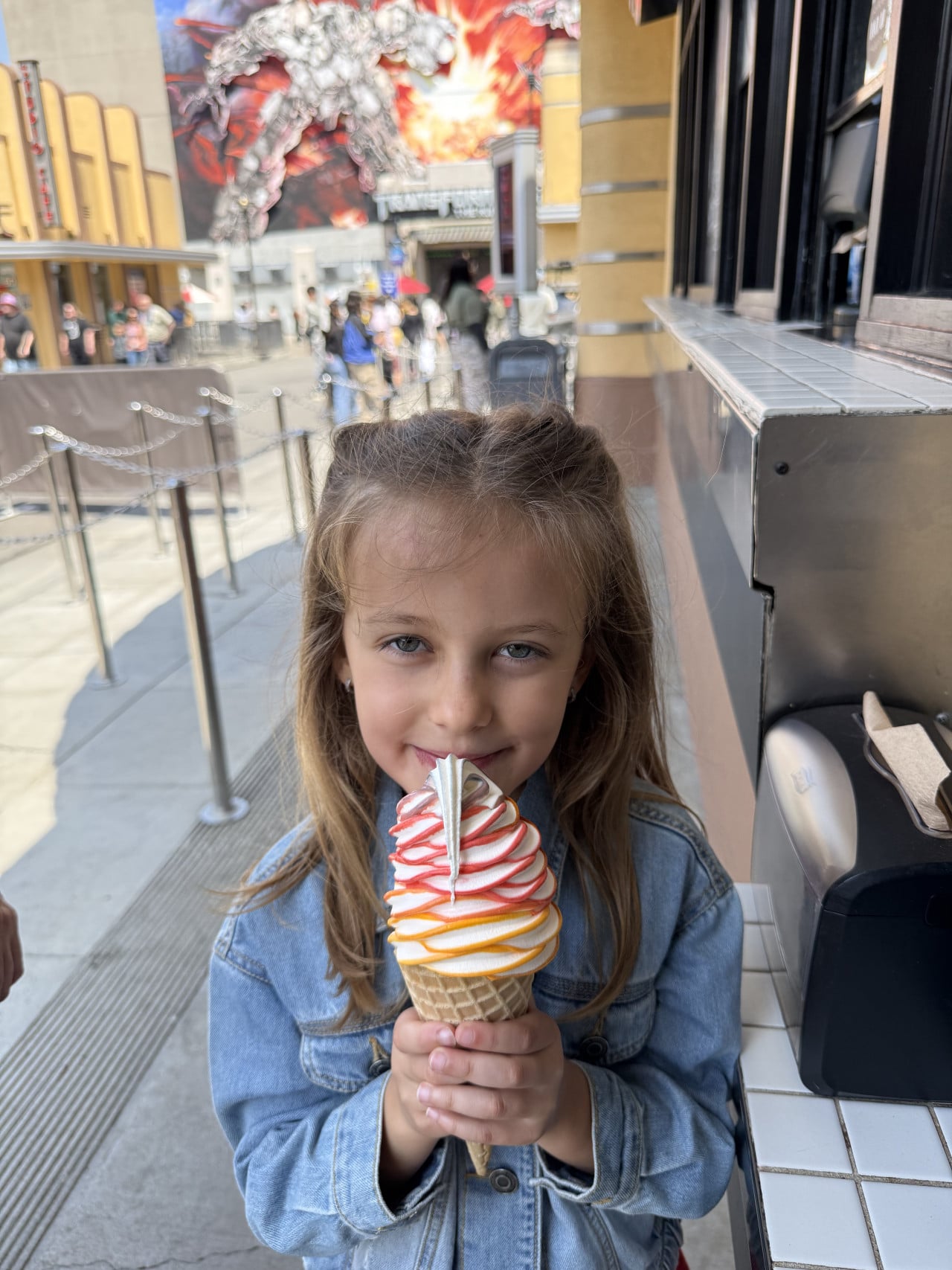 Dívka v džínové bundě drží točenou zmrzlinu v Universal Studios Hollywood.