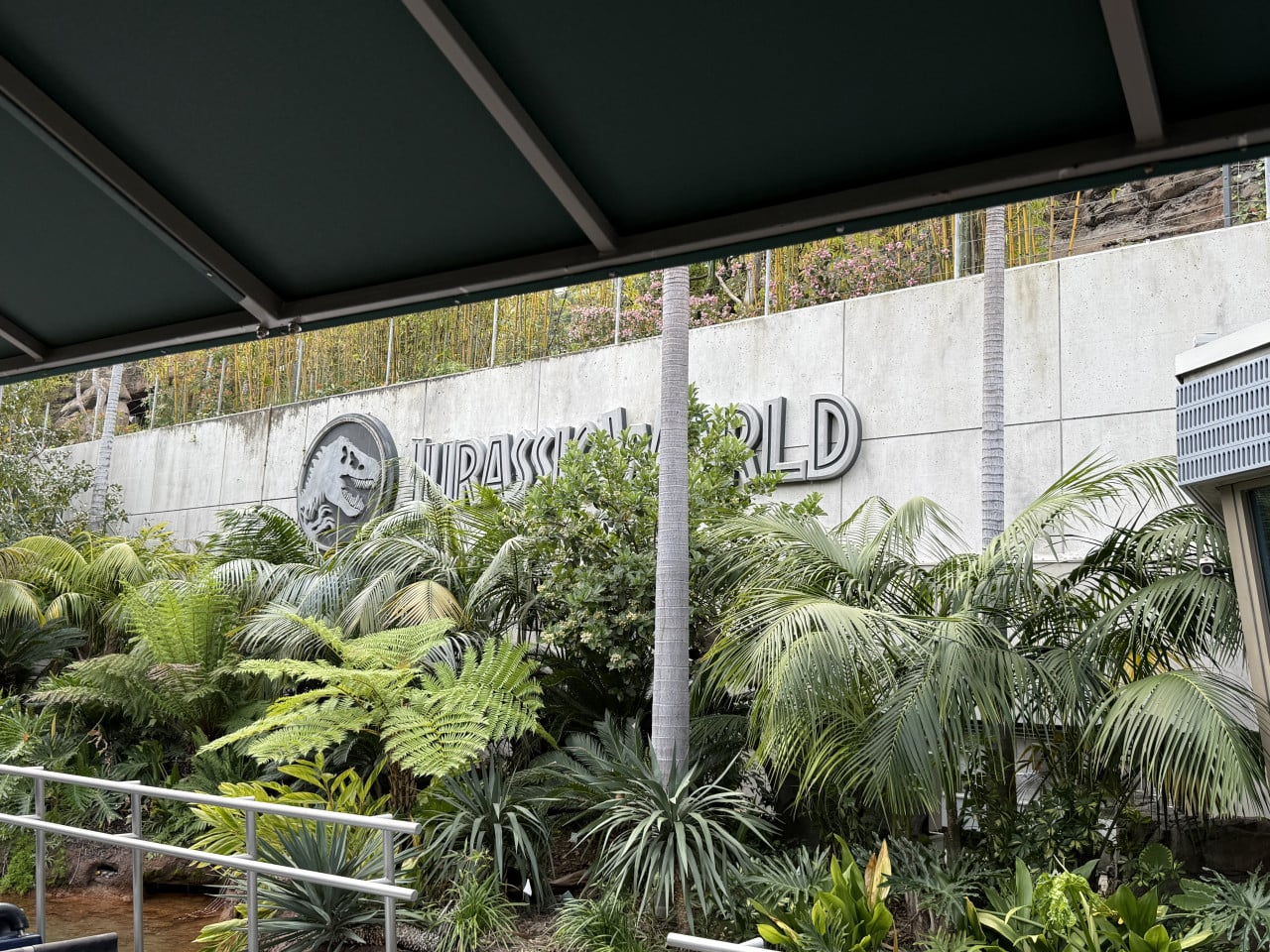 Vchod k atrakci Jurassic World obklopený tropickou zelení v Universal Studios Hollywood