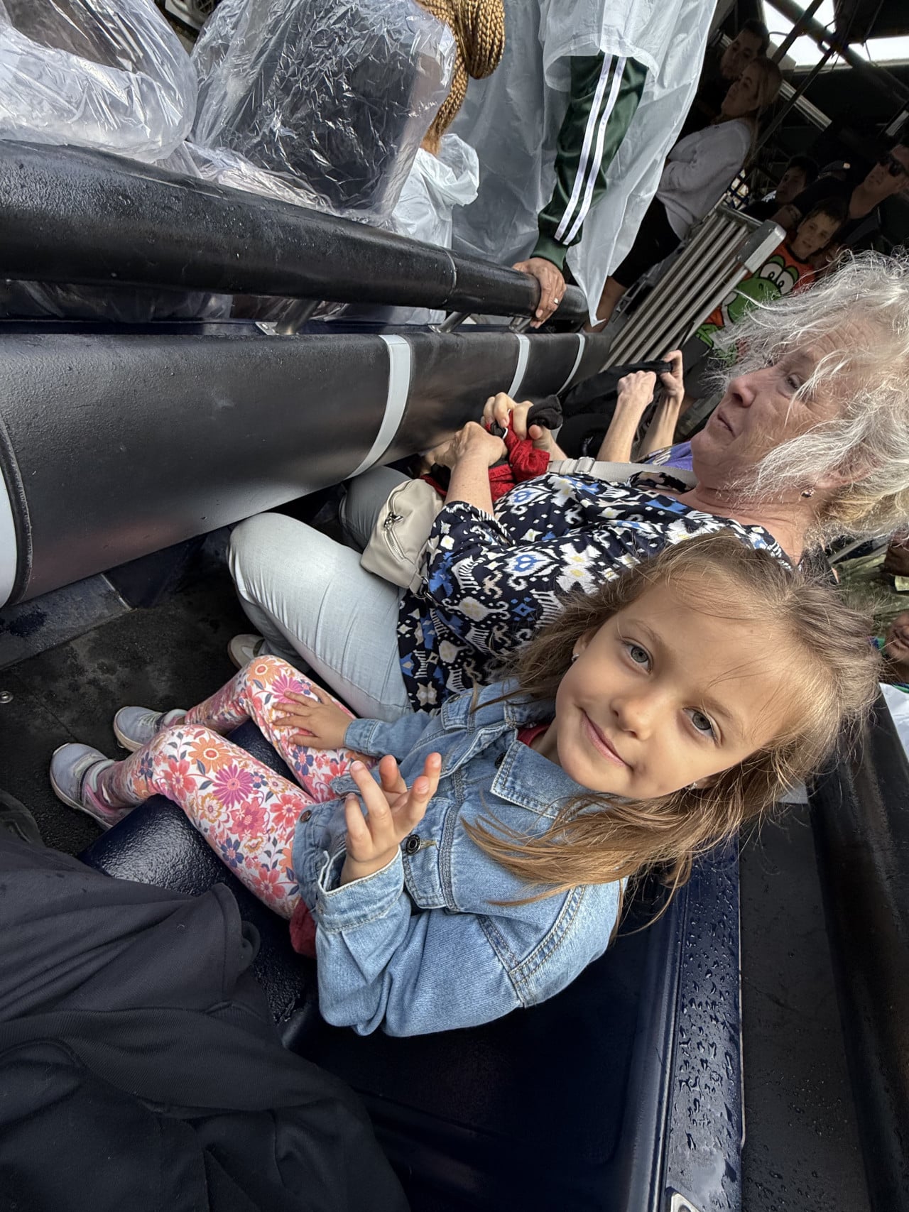 Malá dívka sedí na sedadle v jízdě Universal Studios s ostatními cestujícími.