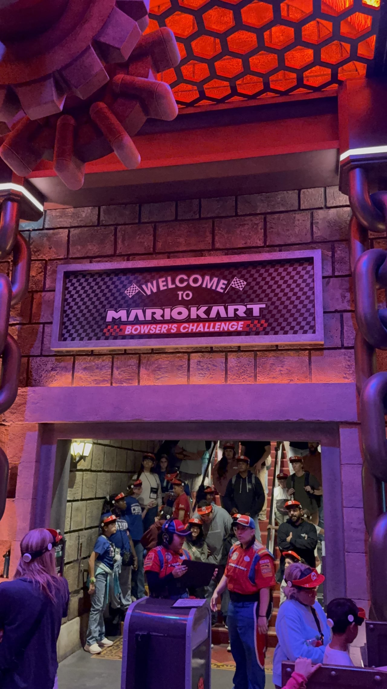 Vstup do atrakce Mario Kart: Bowser’s Challenge s návštěvníky a personálem