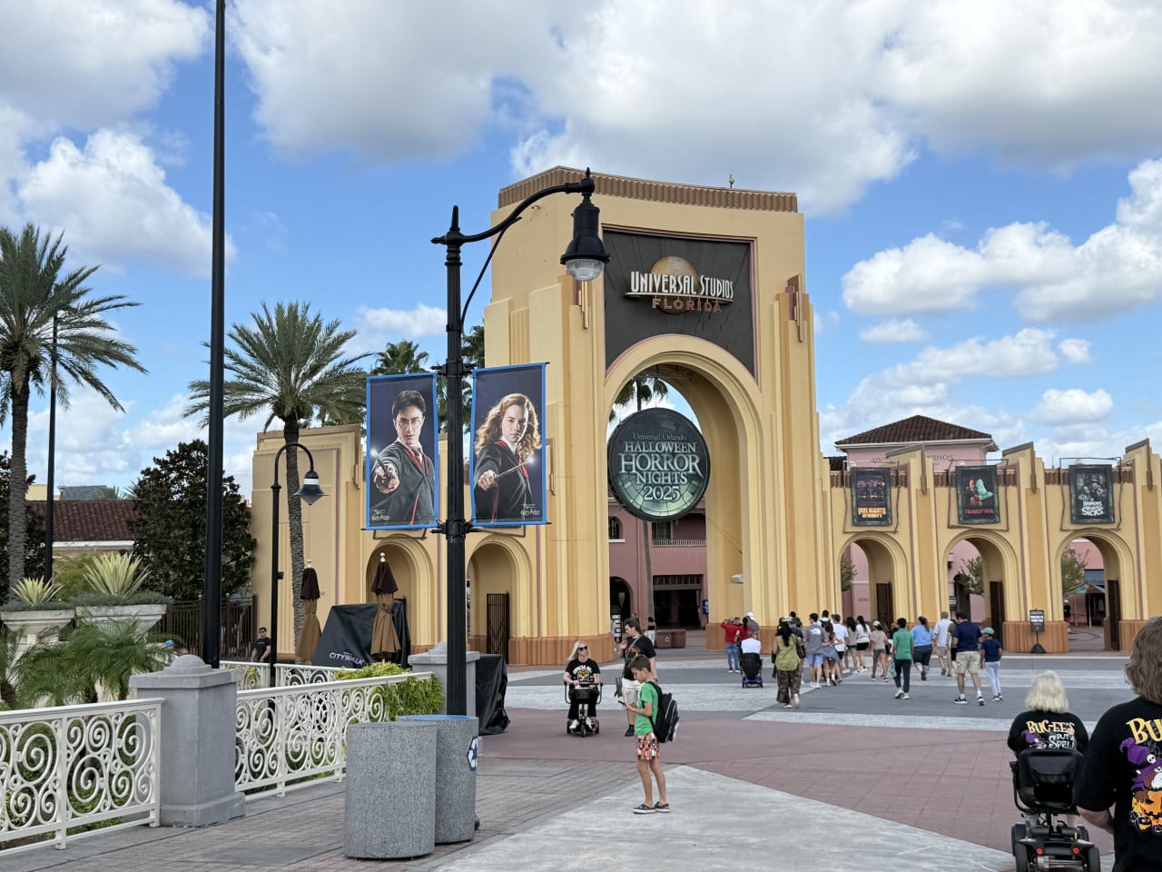 Vstupní brána Universal Studios Florida s nápisy a návštěvníky na promenádě