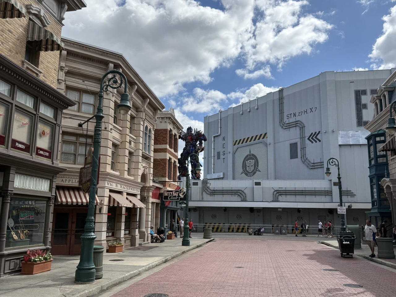 Ulice Universal Studios Orlando s robotem Optimem mezi filmovými kulisami a budovami nestu.